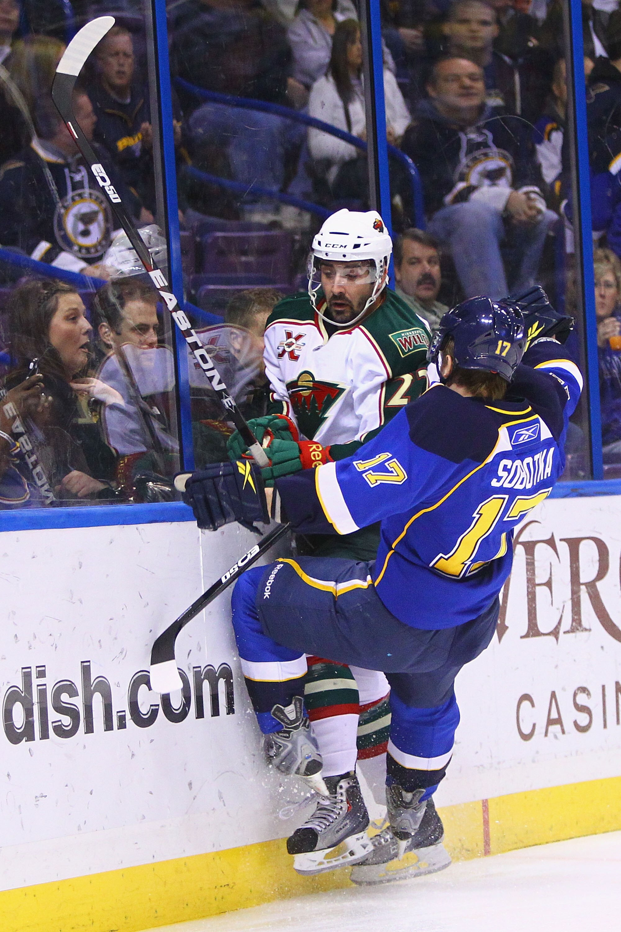 ST. LOUIS, MO - FEBRUARY 11: Vladimir Sobotka #17 of the St. Louis Blues checks Cal Clutterbuck #22 of the Minnesota Wild into the boards at the Scottrade Center on February 11, 2011 in St. Louis, Missouri.  (Photo by Dilip Vishwanat/Getty Images)