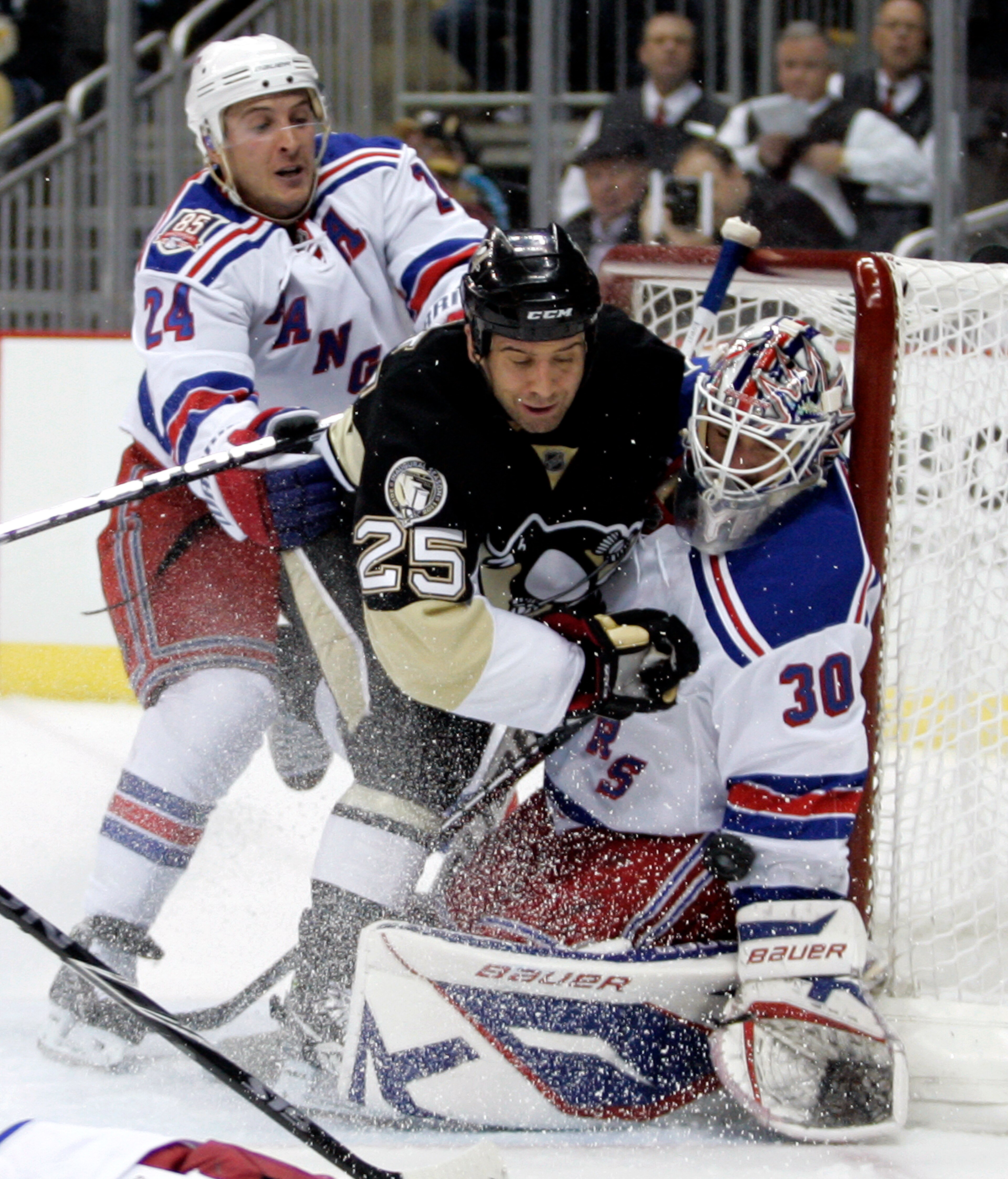 PITTSBURGH, PA - MARCH 20:  Henrik Lundqvist #30 of the New York Rangers makes a save as Maxime Talbot #25 of the Pittsburgh Penguins is checked by Ryan Callahan #24 at Consol Energy Center on March 20, 2011 in Pittsburgh, Pennsylvania.  (Photo by Justin