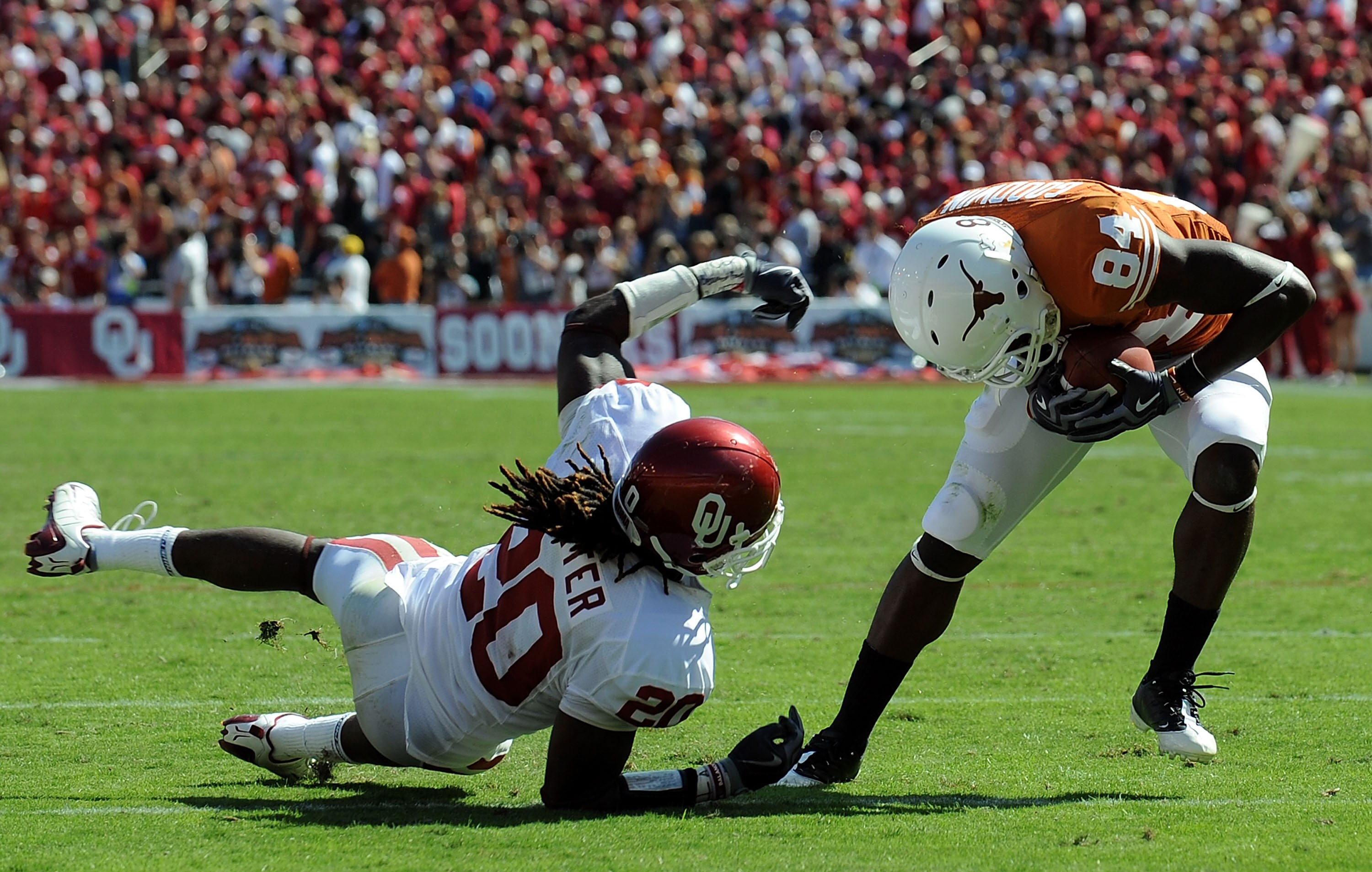 DALLAS - OCTOBER 17:  Wide receiver Marquise Goodwin #84 of the Texas Longhorns runs for a touchdown against Quinton Carter #20 of the Oklahoma Sooners at Cotton Bowl on October 17, 2009 in Dallas, Texas.  (Photo by Ronald Martinez/Getty Images)