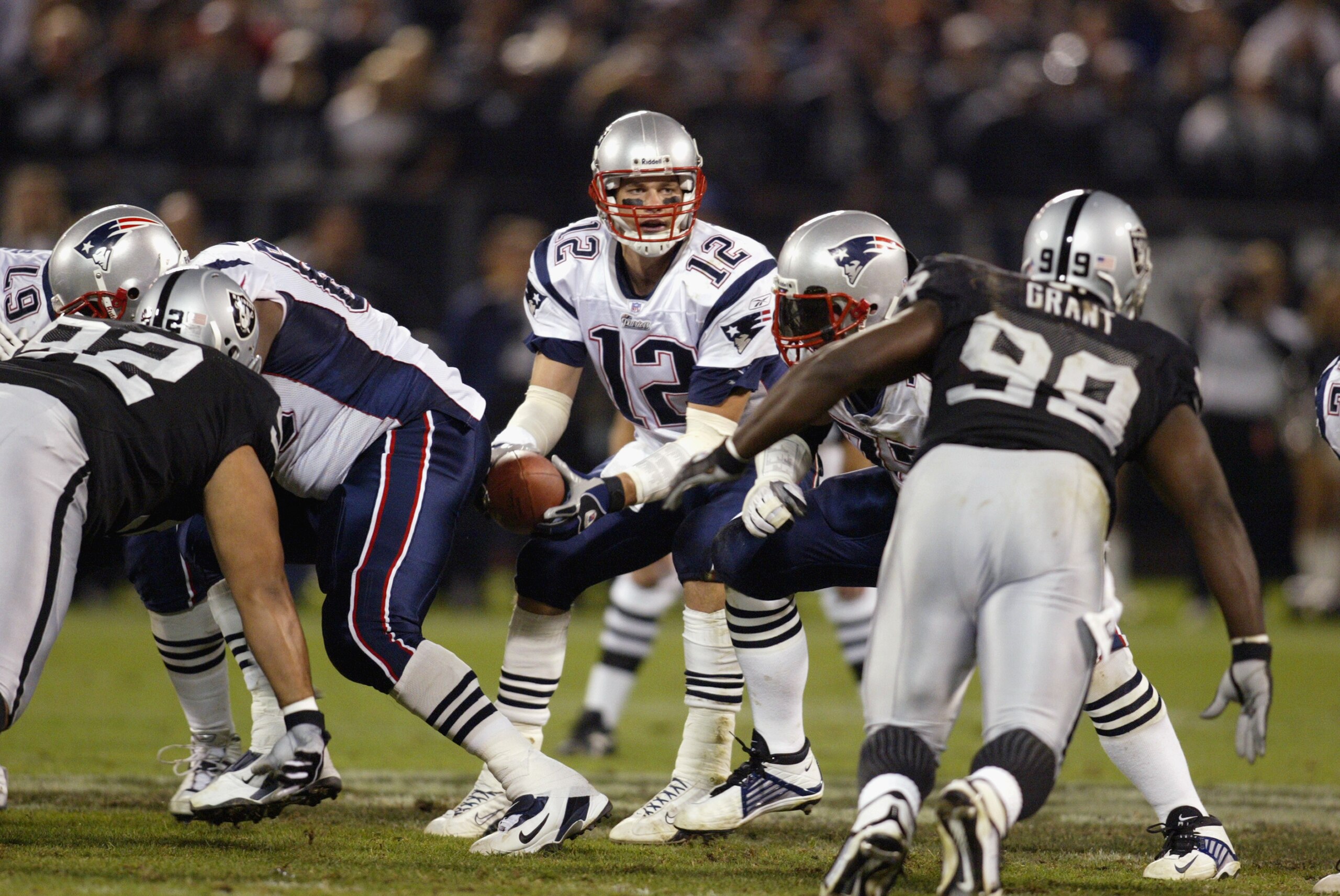 OAKLAND, CA - NOVEMBER 17:  Tom Brady #12 of the New England Patriots takes the snap from center during the game against the Oakland Raiders on November 17, 2002 at Network Associates Coliseum in Oakland, California. The Raiders defeated the Patriots 27-2