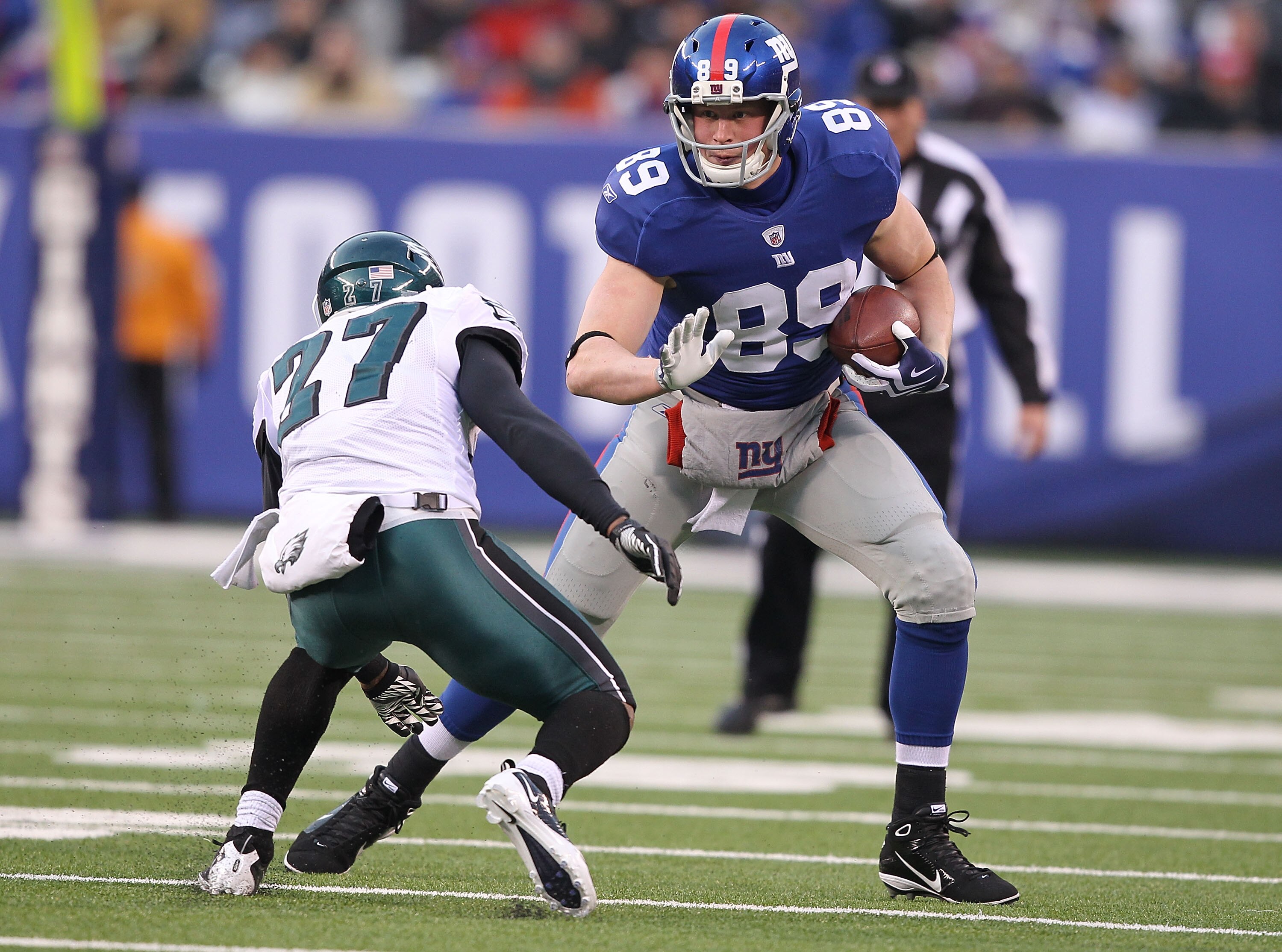 EAST RUTHERFORD, NJ - DECEMBER 19:  Kevin Boss #89 of the New York Giants eludes the tackle of Quintin Mikell #27 of the Philadelphia Eagles during their game on December 19, 2010 at The New Meadowlands Stadium in East Rutherford, New Jersey.  (Photo by A