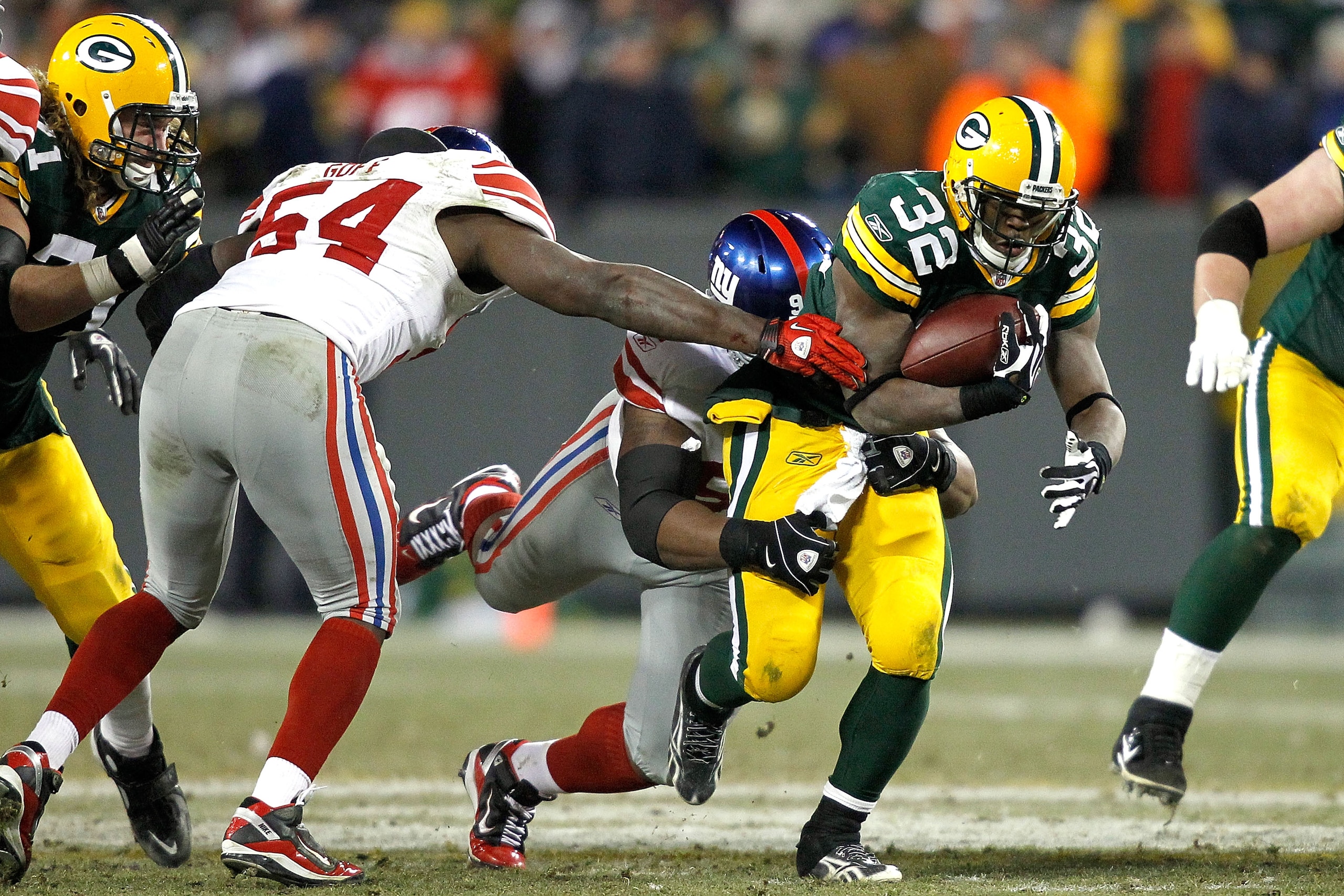GREEN BAY, WI - DECEMBER 26:  Brandon Jackson #32 of the Green Bay Packers is tackled by Linval Joseph #97 of the New York Giants at Lambeau Field on December 26, 2010 in Green Bay, Wisconsin.  (Photo by Matthew Stockman/Getty Images)