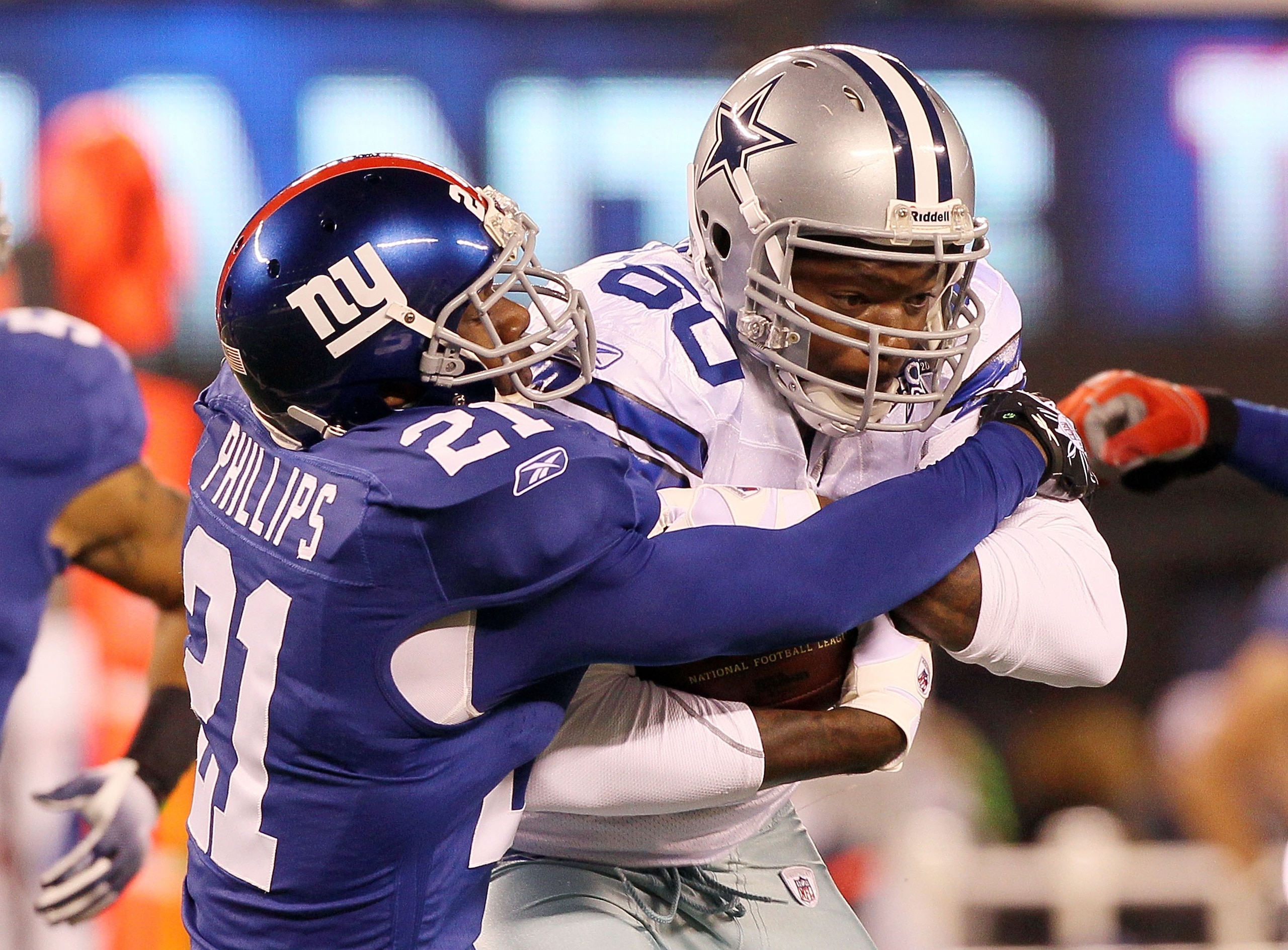 EAST RUTHERFORD, NJ - NOVEMBER 14:  Martellus Bennett #80 of the Dallas Cowboys is tackled by Kenny Phillips #21 of the New York Giants on November 14, 2010 at the New Meadowlands Stadium in East Rutherford, New Jersey.  (Photo by Jim McIsaac/Getty Images