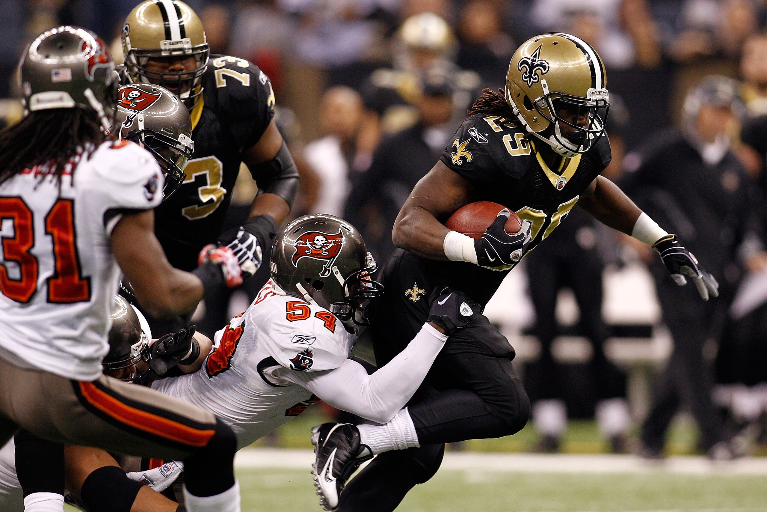 NEW ORLEANS, LA - JANUARY 02:  Chris Ivory #29 of the New Orleans Saints is tackled by Geno Hayes #54 of the Tampa Bay Buccaneers at the Louisiana Superdome on January 2, 2011 in New Orleans, Louisiana.  (Photo by Chris Graythen/Getty Images)