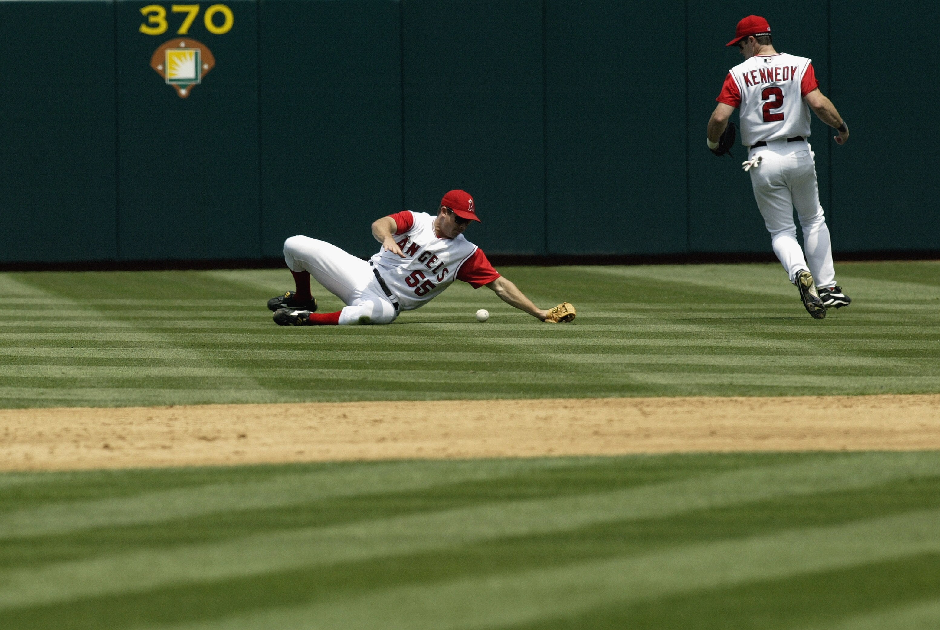 ANAHEIM, CA - JULY 26:  Rightfielder Jeff DaVanon #55 of the Anaheim Angels can't catch a bloop single hit by Miguel Tejada of the Oakland A's as second baseman Adam Kennedy #2 also pursues in the third inning on July 26, 2003 at Edison Field in Anaheim,