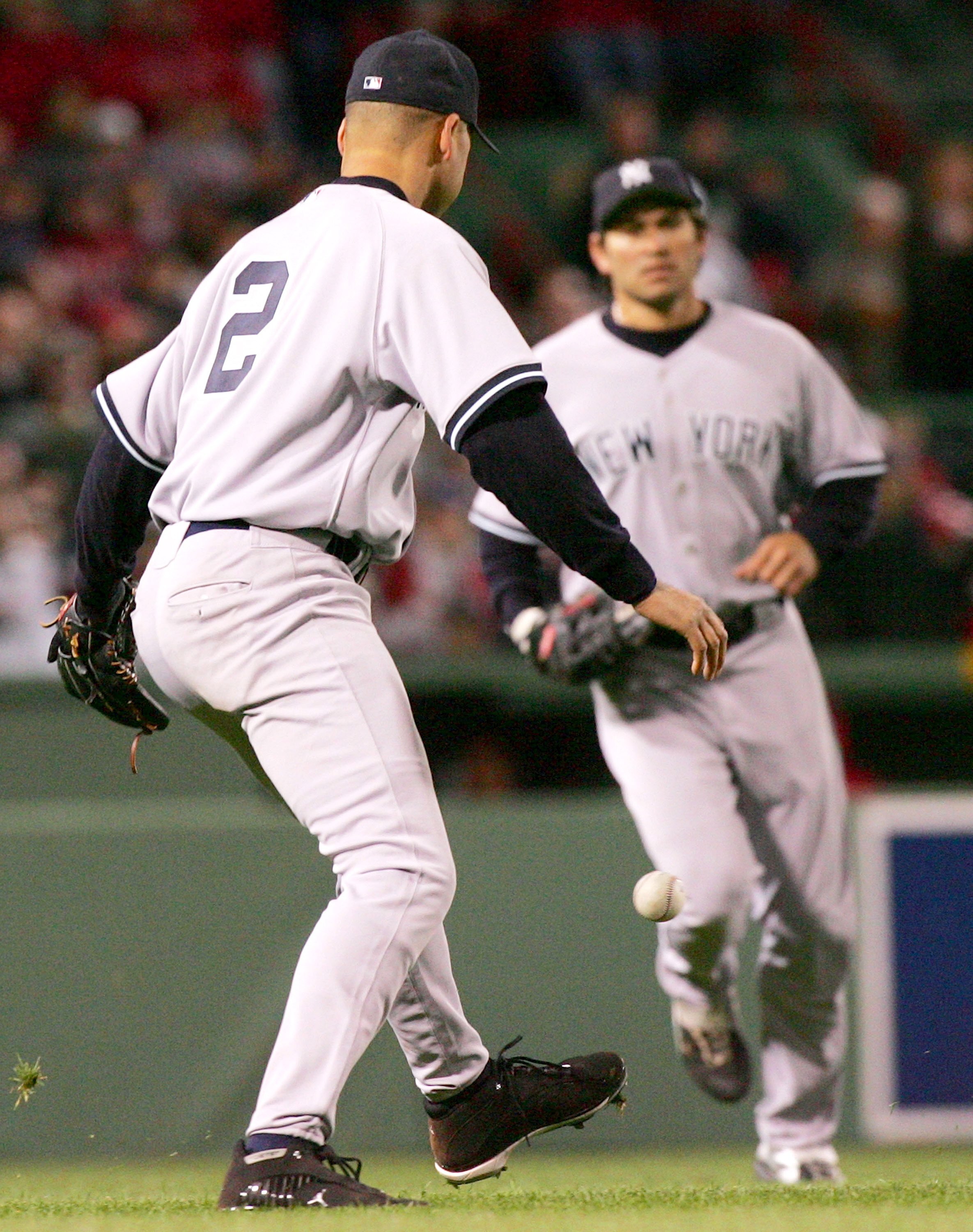 BOSTON - MAY 01:  Derek Jeter #2 of the New York Yankees tries to recover the ball after a bloop base hit from Trot Nixon of the Boston Red Sox as Johnny Damon #18 loks on during thier game at Fenway Park on May 1, 2006 in Boston, Massachusetts.  (Photo b