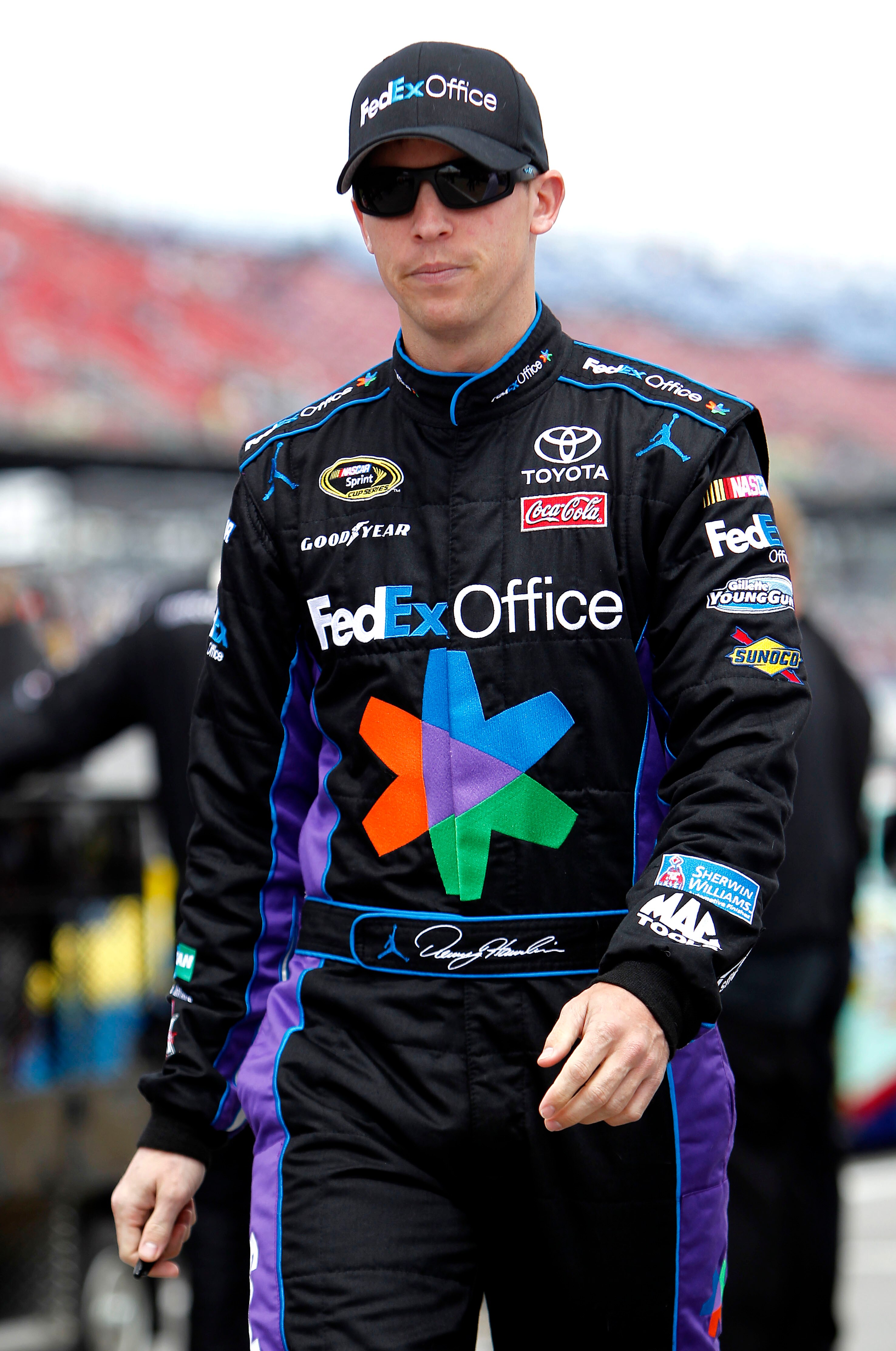 TALLADEGA, AL - APRIL 16:  Denny Hamlin, driver of the #11 FedEx Office Toyota, walks on the grid during qualifying for the NASCAR Sprint Cup Series Aaron's 499 at Talladega Superspeedway on April 16, 2011 in Talladega, Alabama.  (Photo by Jeff Zelevansky