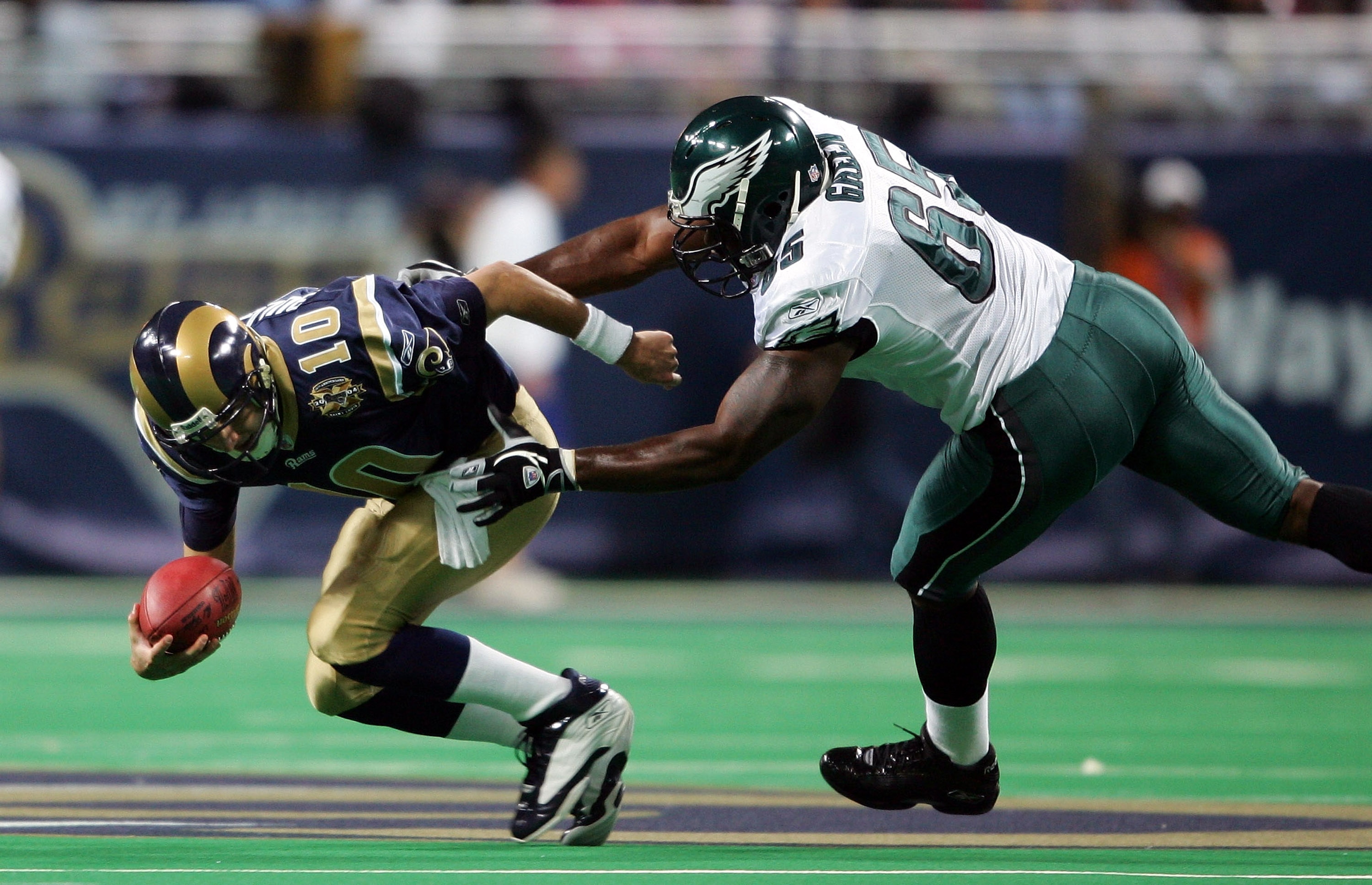 ST.LOUIS - DECEMBER 27:  Quarterback Marc Bulger #10 of the St. Louis Rams is sacked by Jamaal Green #65 of the Philadelphia Eagles on December 27, 2004 at the Edward Jones Dome in St. Louis, Missouri.  (Photo by Elsa/Getty Images)