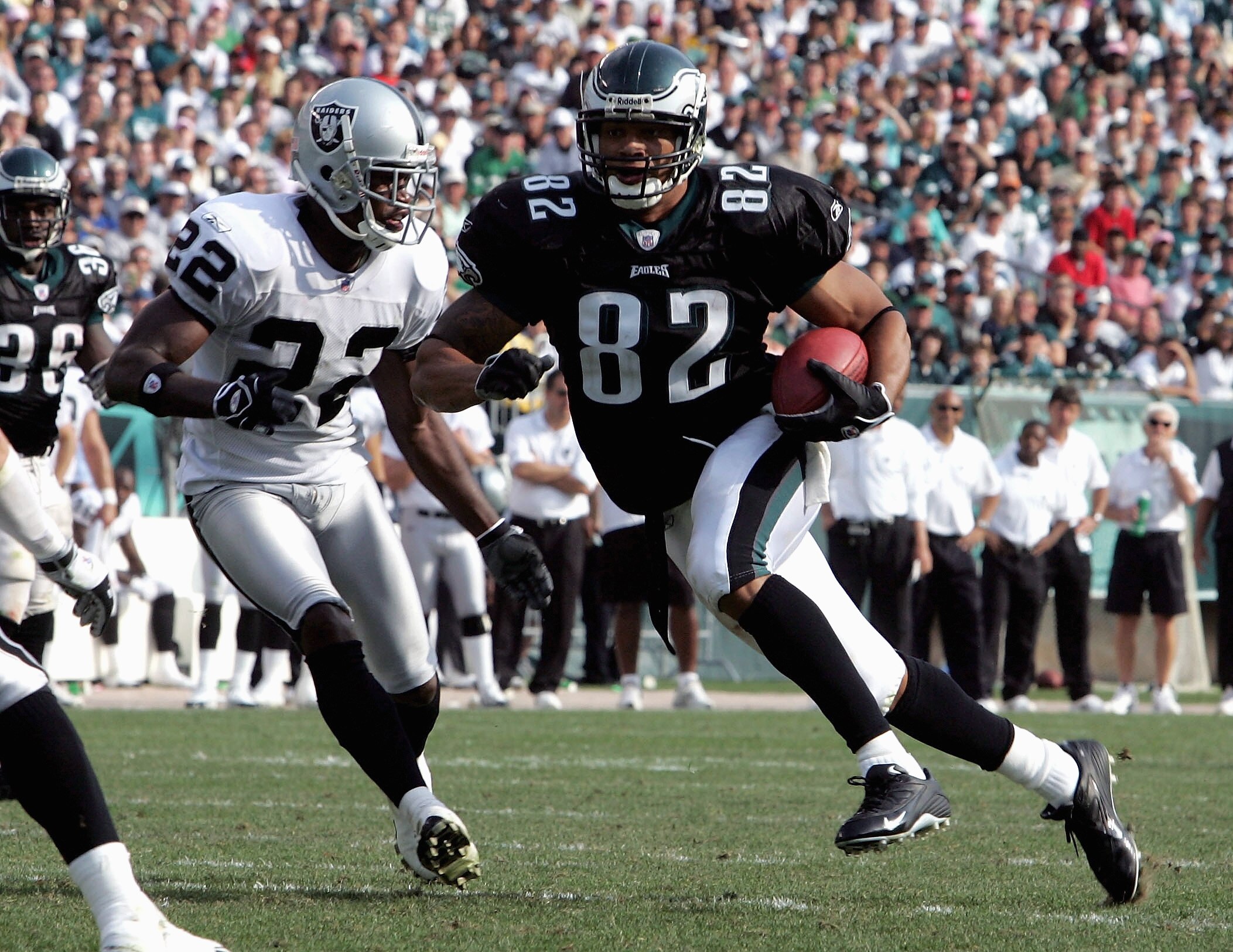 PHILADELPHIA, PA -SEPTEMBER 25: Tight end LJ Smith #82 of the Philadelphia Eagles runs the ball past cornerback Renaldo Hill #22 of the Oakland Raiders during their game on September 25, 2005 at Lincoln Financial Field in Philadelphia, Pennsylvannia.The E