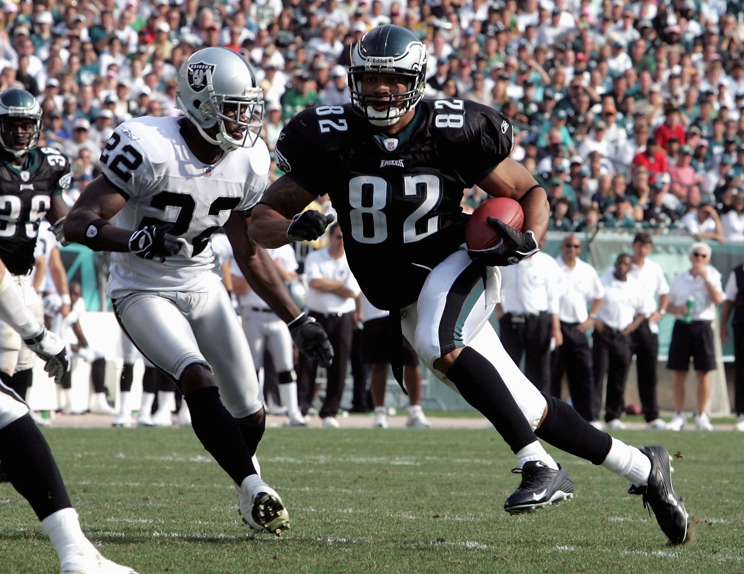 PHILADELPHIA, PA -SEPTEMBER 25: Tight end LJ Smith #82 of the Philadelphia Eagles runs the ball past cornerback Renaldo Hill #22 of the Oakland Raiders during their game on September 25, 2005 at Lincoln Financial Field in Philadelphia, Pennsylvannia.The E