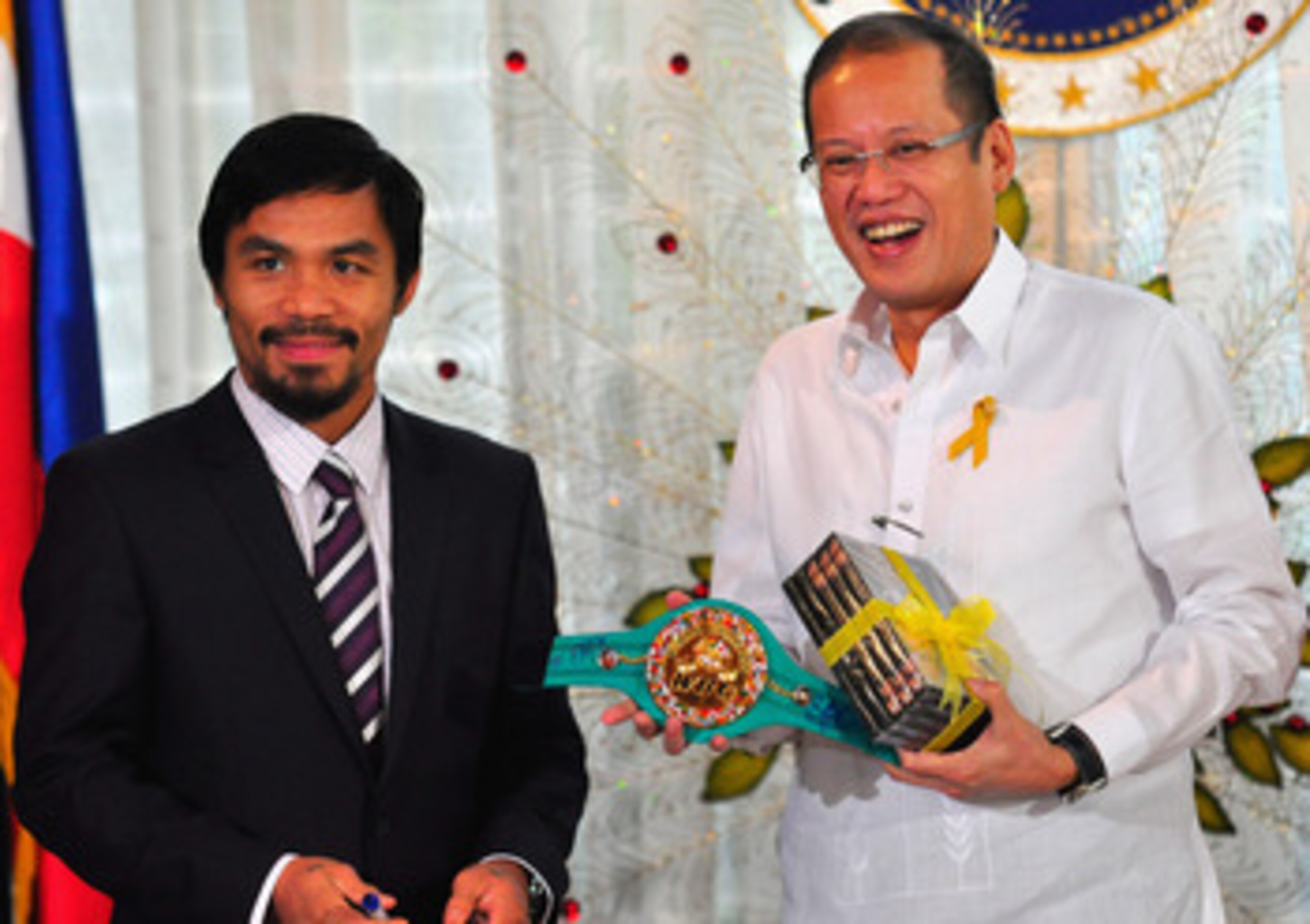 MANILA, PHILIPPINES - NOVEMBER 20:  Boxer and congressman, Manny Pacquiao gives President Benigno Aquino III a shirt and memorabilia following his win of the WBC super welterweight crown against Mexican Antonio Margarito on November 20, 2010 in Manila, Ph
