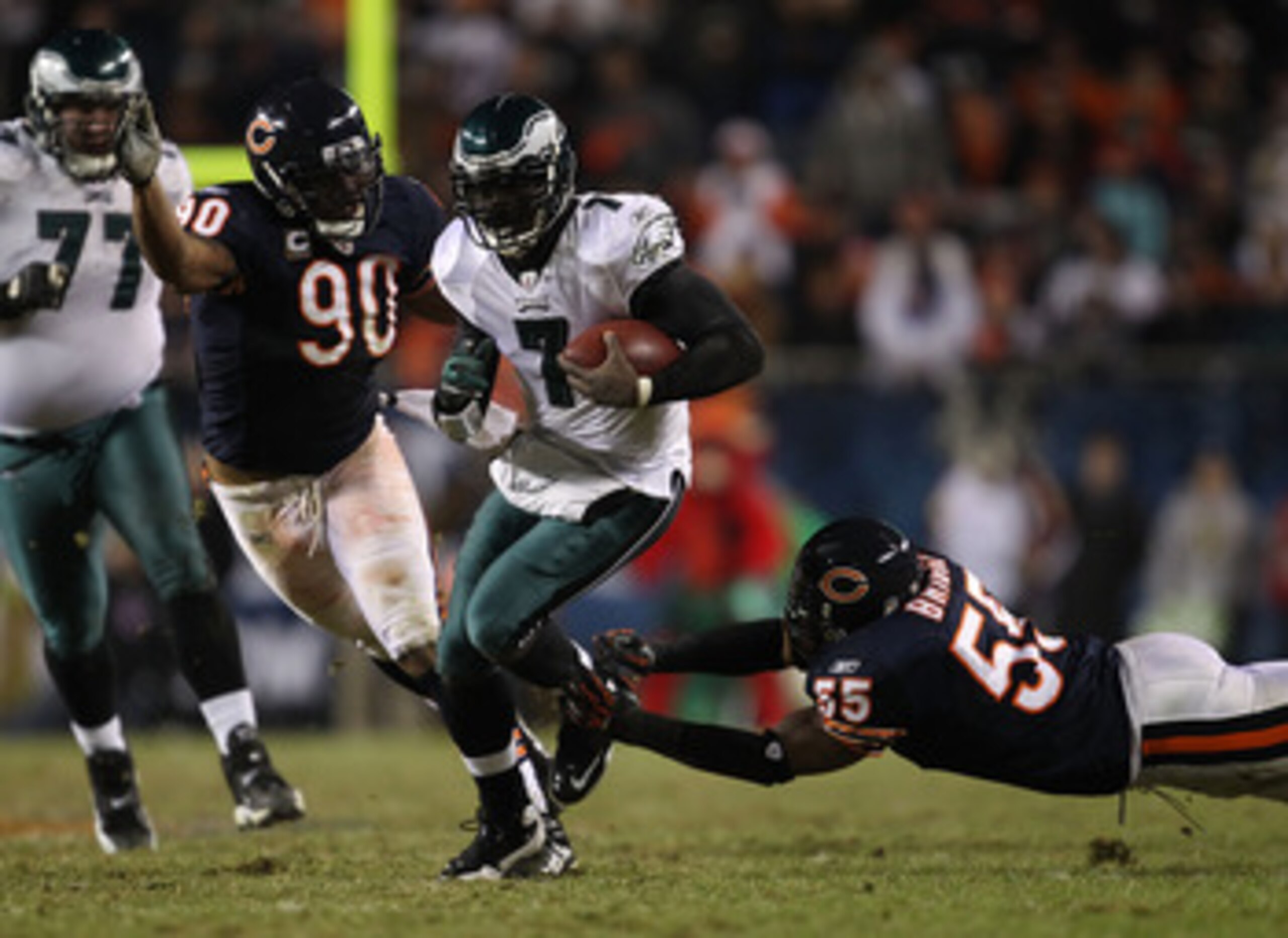 CHICAGO - NOVEMBER 28: Michael Vick #7 of the Philadelphia Eagles breaks a tackle by Lance Briggs #55 of the Chicago Bears as Julius Peppers #90 closes in at Soldier Field on November 28, 2010 in Chicago, Illinois. The Bears defeated the Eagles 31-26. (Ph CHICAGO - NOVEMBER 28: Michael Vick #7 of the Philadelphia Eagles breaks a tackle by Lance Briggs #55 of the Chicago Bears as Julius Peppers #90 closes in at Soldier Field on November 28, 2010 in Chicago, Illinois. The Bears defeated the Eagles 31-26. (Ph