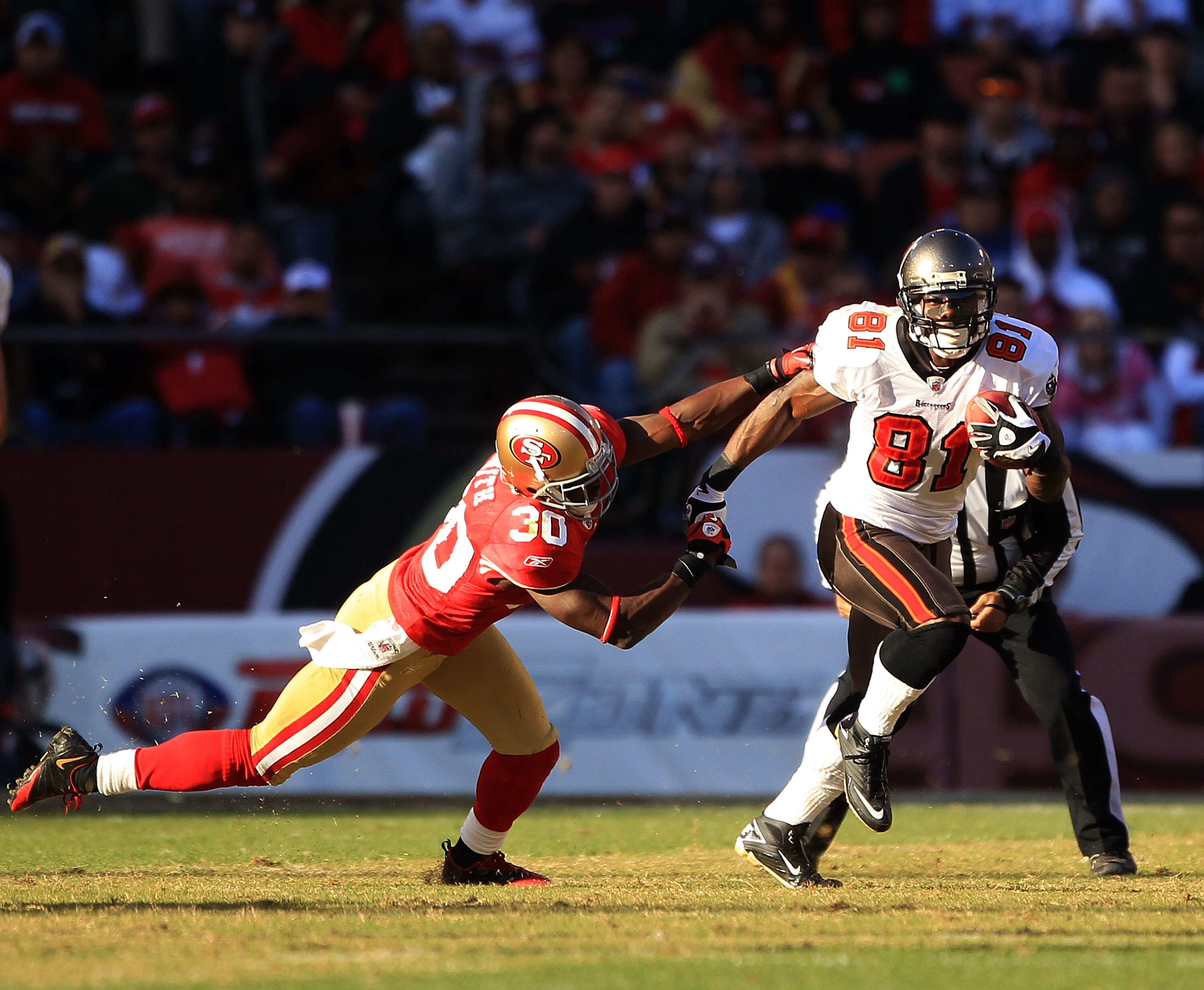 SAN FRANCISCO - NOVEMBER 21:  Micheal Spurlock #81 of the Tampa Bay Buccaneers tries turnover outrun Reggie Smith #30 of the San Francisco 49ers at Candlestick Park on November 21, 2010 in San Francisco, California.  (Photo by Ezra Shaw/Getty Images)
