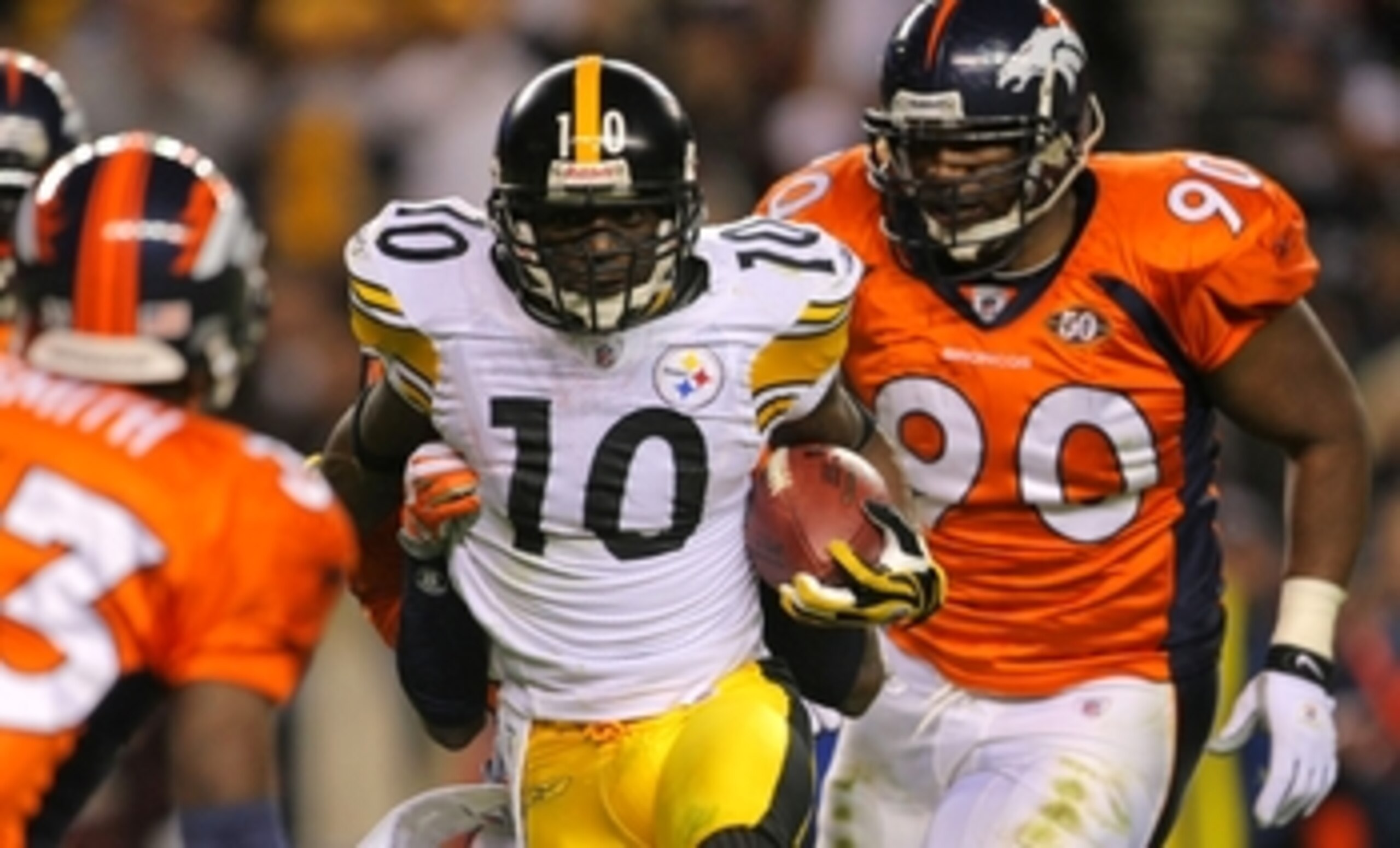 DENVER - NOVEMBER 09: Santonio Holmes #10 of the Pittsburgh Steelers runs with the ball against  Alphonso Smith #33 and Travis Kirschke #90 of the Denver Broncos at Invesco Field at Mile High on November 09, 2009 in Denver, Colorado. (Photo by Doug Pensin