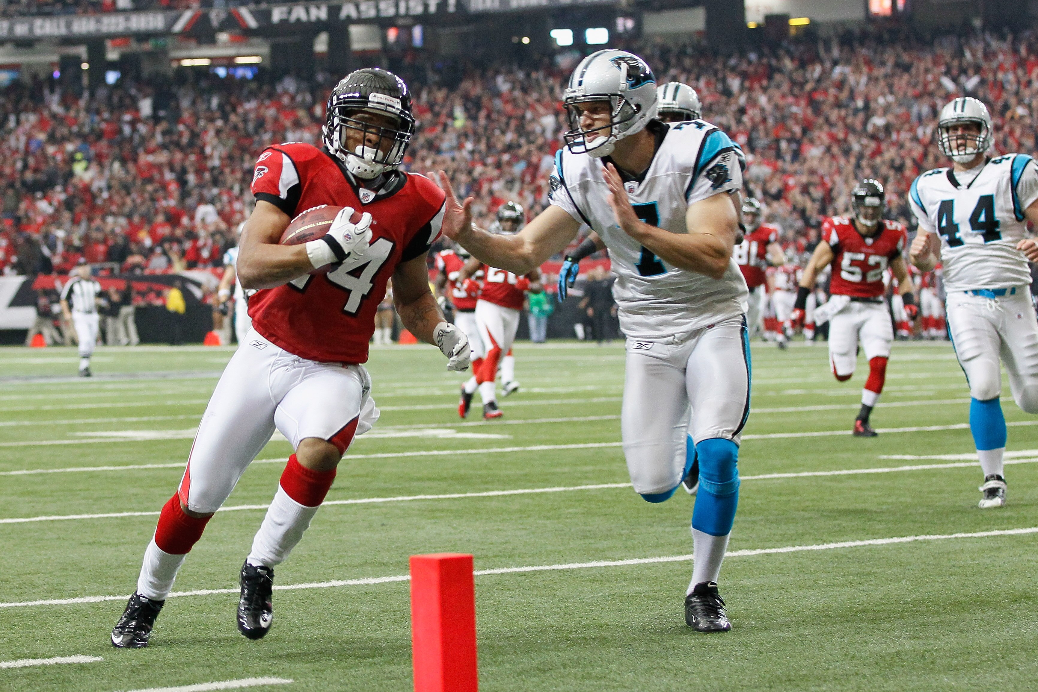 ATLANTA, GA - JANUARY 02:  Eric Weems #14 of the Atlanta Falcons scores a touchdown on a punt return past Jason Baker #7 of the Carolina Panthers at Georgia Dome on January 2, 2011 in Atlanta, Georgia.  (Photo by Kevin C. Cox/Getty Images)