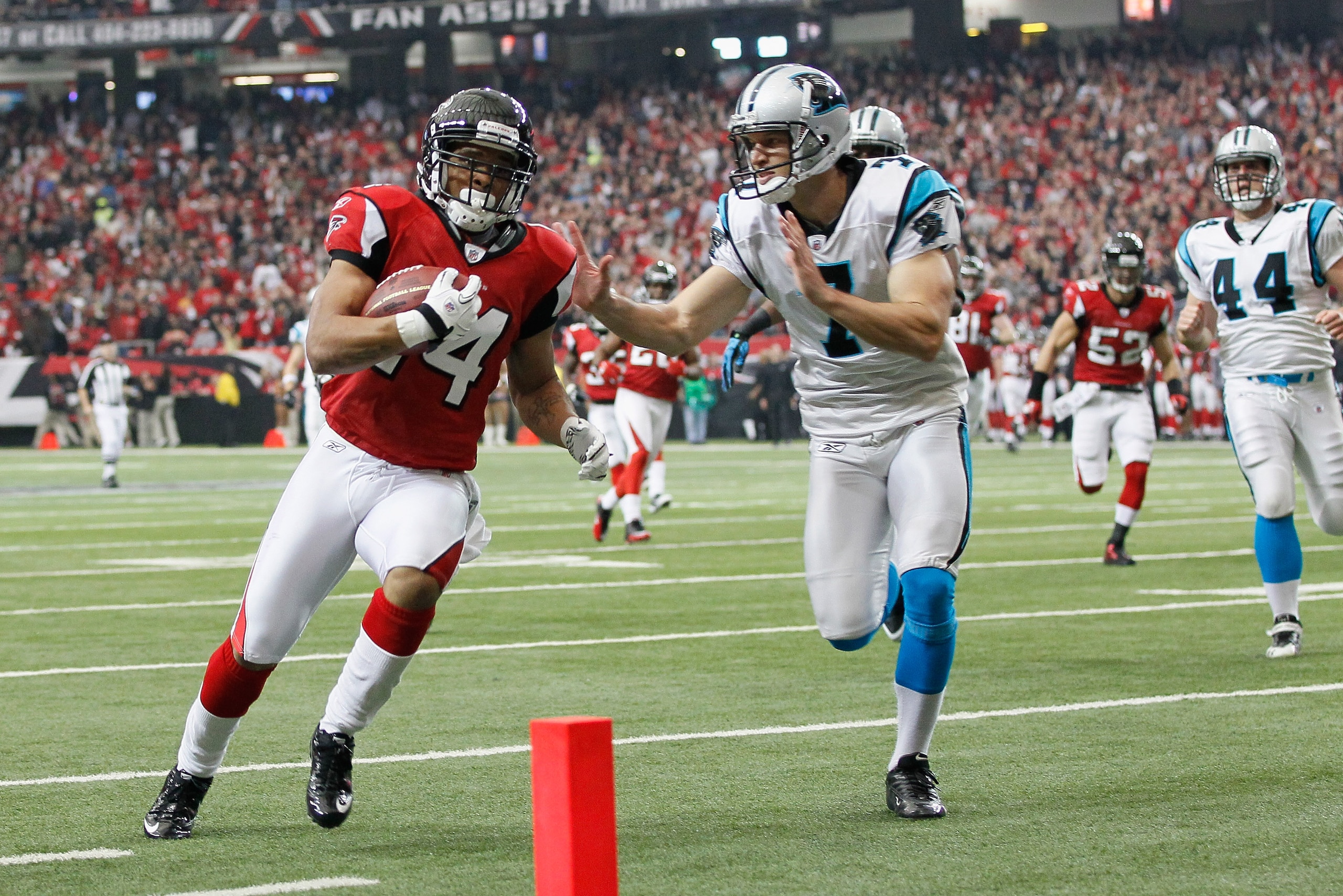 ATLANTA, GA - JANUARY 02:  Eric Weems #14 of the Atlanta Falcons scores a touchdown on a punt return past Jason Baker #7 of the Carolina Panthers at Georgia Dome on January 2, 2011 in Atlanta, Georgia.  (Photo by Kevin C. Cox/Getty Images)