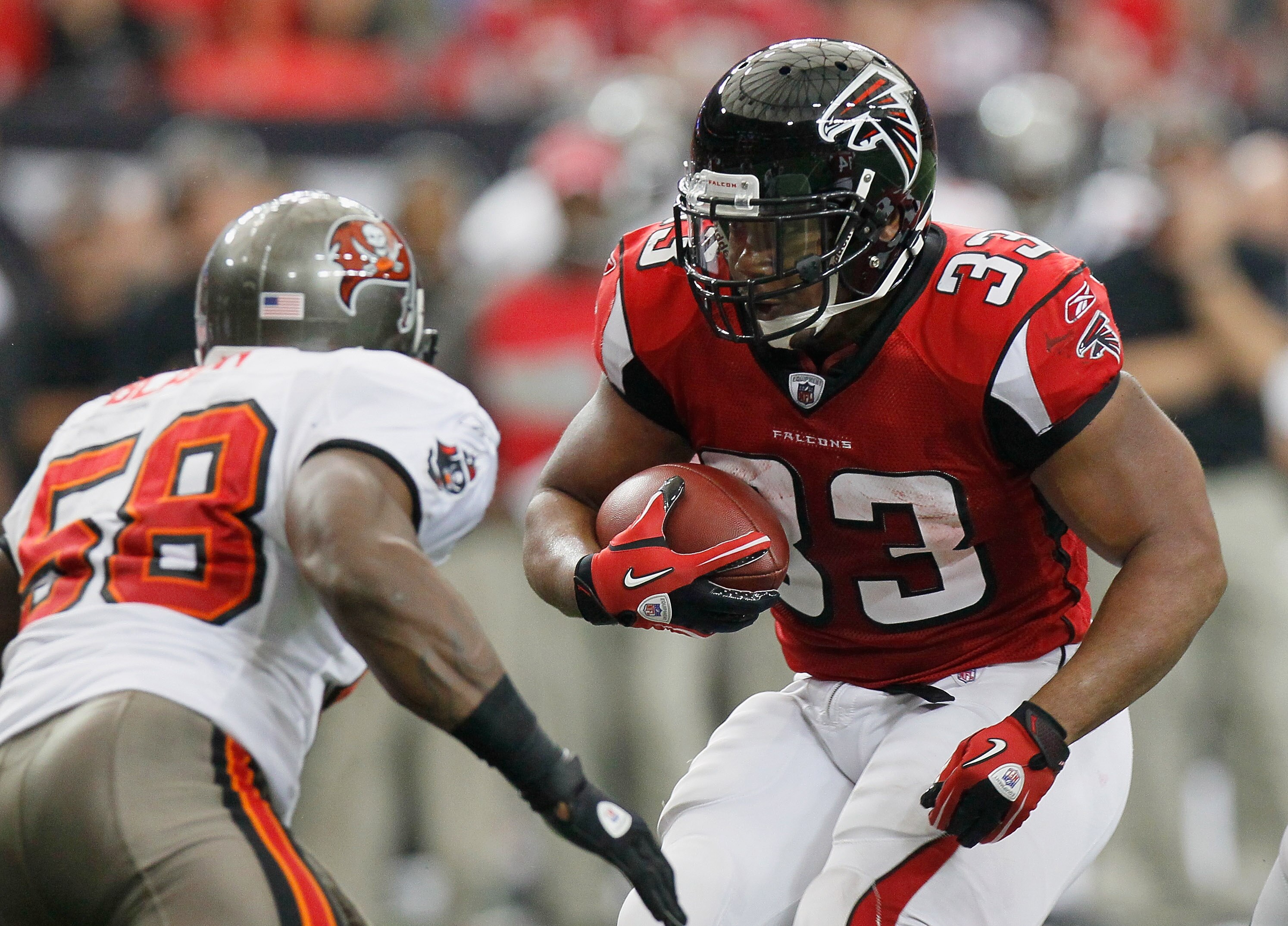 ATLANTA - NOVEMBER 07:  Michael Turner #33 of the Atlanta Falcons rushes upfield against Quincy Black #58 of the Tampa Bay Buccaneers at Georgia Dome on November 7, 2010 in Atlanta, Georgia.  (Photo by Kevin C. Cox/Getty Images)