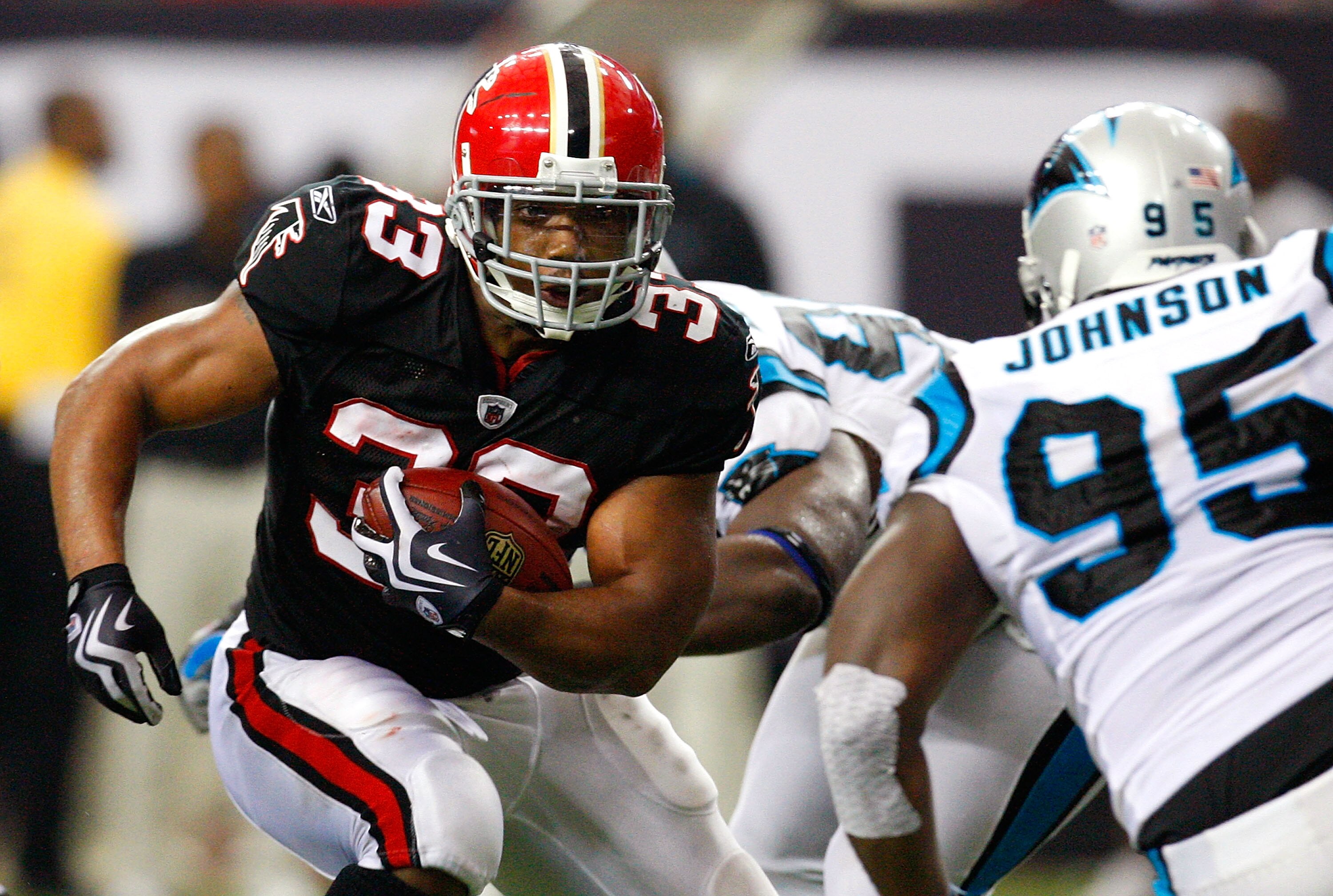 ATLANTA - SEPTEMBER 20:  Michael Turner #33 of the Atlanta Falcons rushes upfield against Charles Johnson #95 of the Carolina Panthers at Georgia Dome on September 20, 2009 in Atlanta, Georgia.  (Photo by Kevin C. Cox/Getty Images)