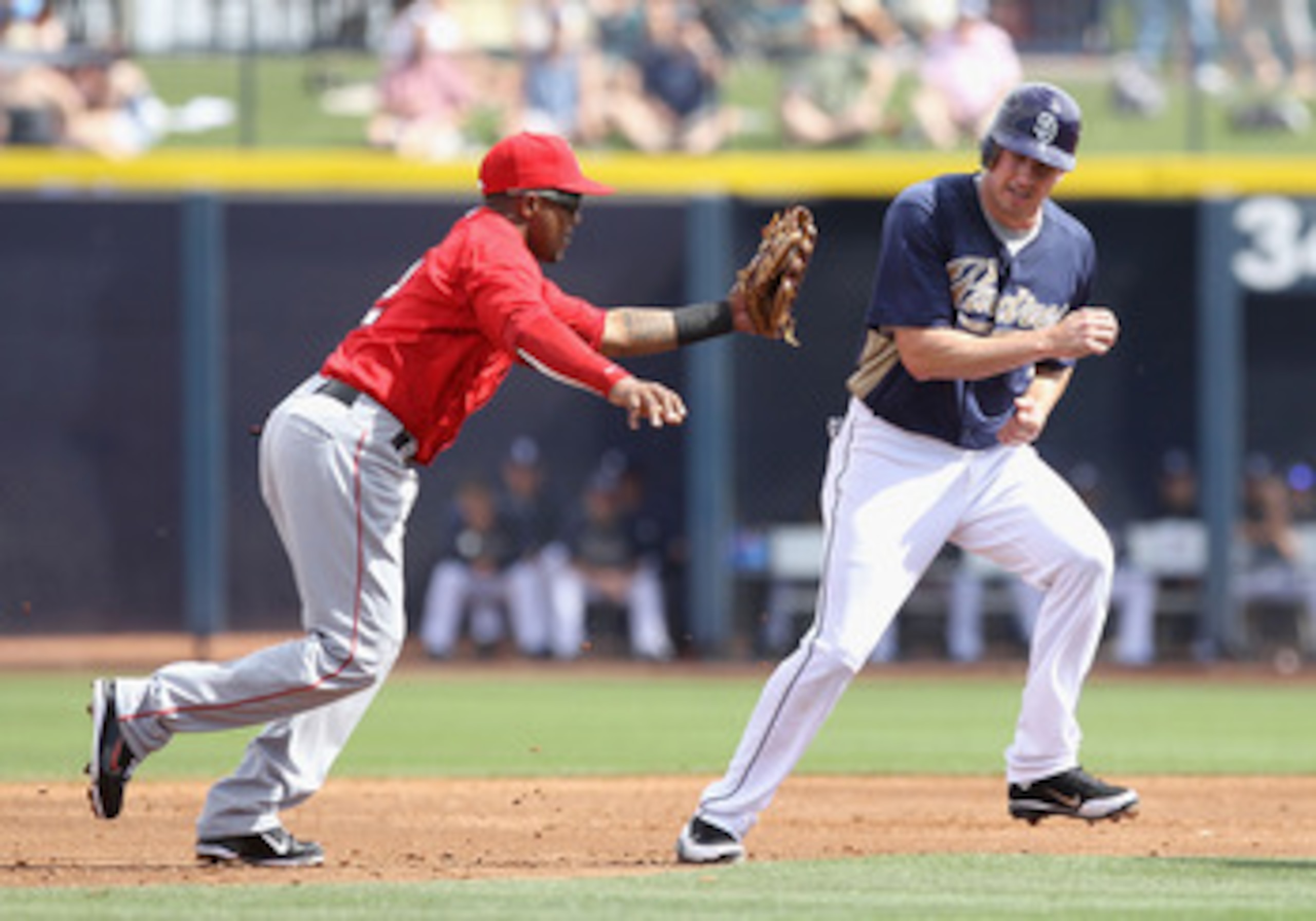 PEORIA, AZ - MARCH 15:  Infielder Erick Aybar #2 of the Los Angeles Angels of Anaheim tags out Brad Hawpe #11 of the San Diego Padres during the third inning of the spring training game at Peoria Stadium on March 15, 2011 in Peoria, Arizona.  (Photo by Ch
