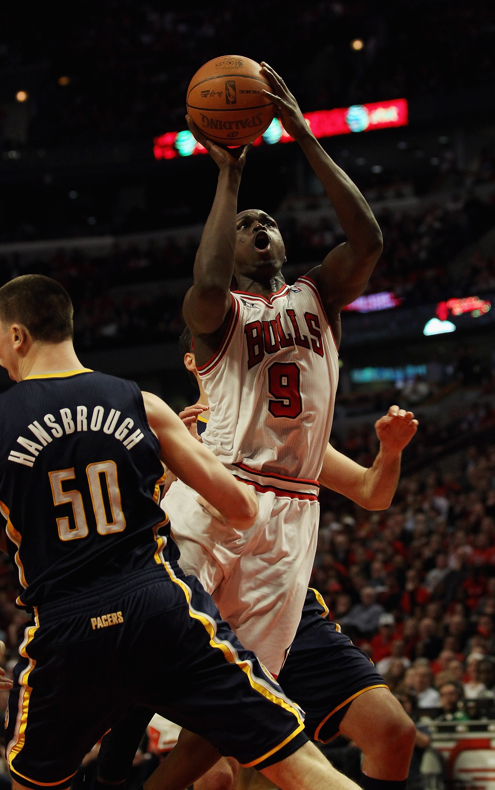 CHICAGO, IL - APRIL 18: Loul Deng #9 of the Chicago Bulls puts up a shot between Tyler Hansbrough #50 and Jeff Foster #10 of the Indiana Pacers in Game Two of the Eastern Conference Quarterfinals in the 2011 NBA Playoffs at the United Center on April 18,