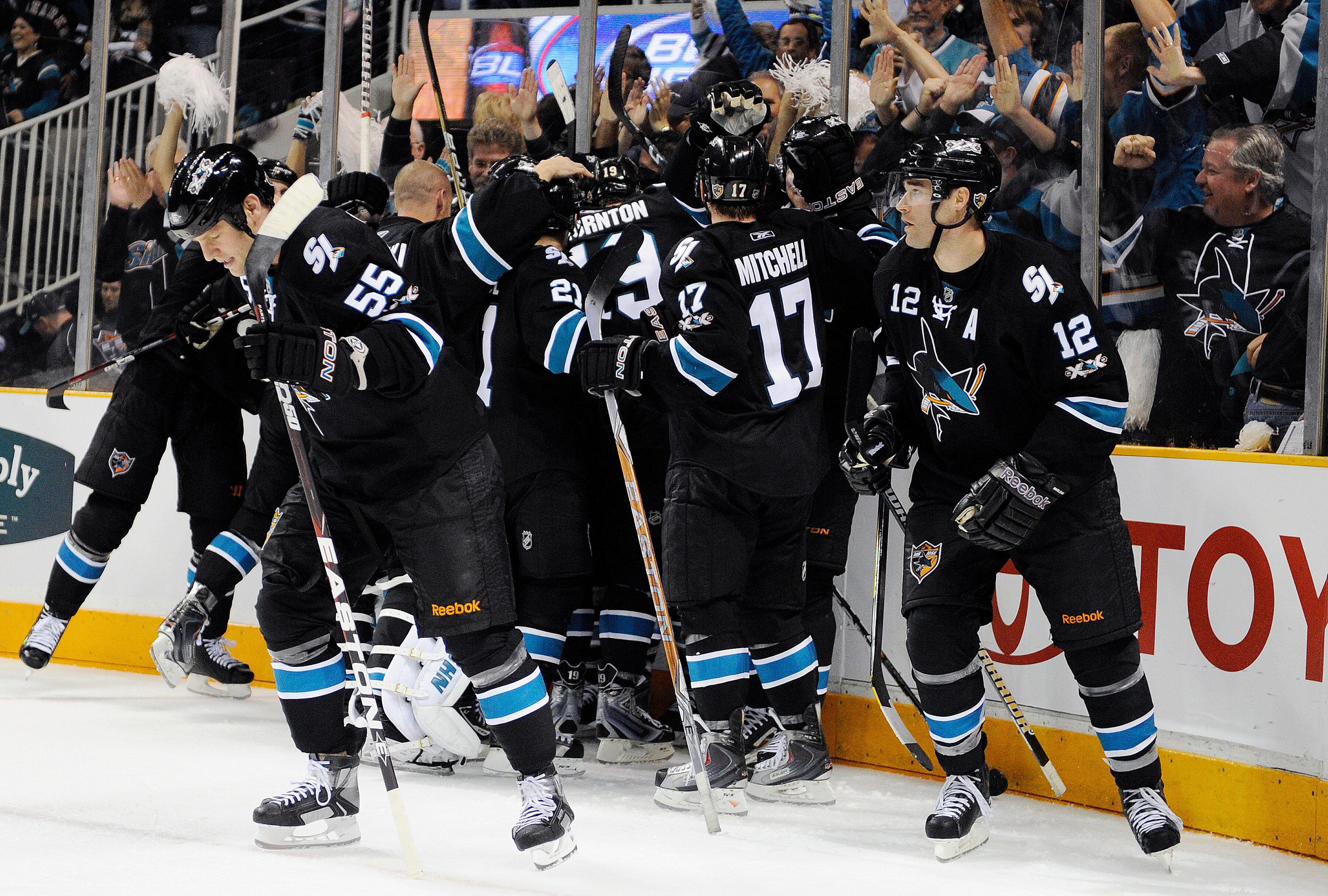 SAN JOSE, CA - APRIL 14: Joe Pavelski #8 of the San Jose Sharks is smothered by his teammates after he scored the winning goal in overtime against the Los Angeles Kings in Game One of the Western Conference Quarterfinals  during the 2011 NHL Stanley Cup P
