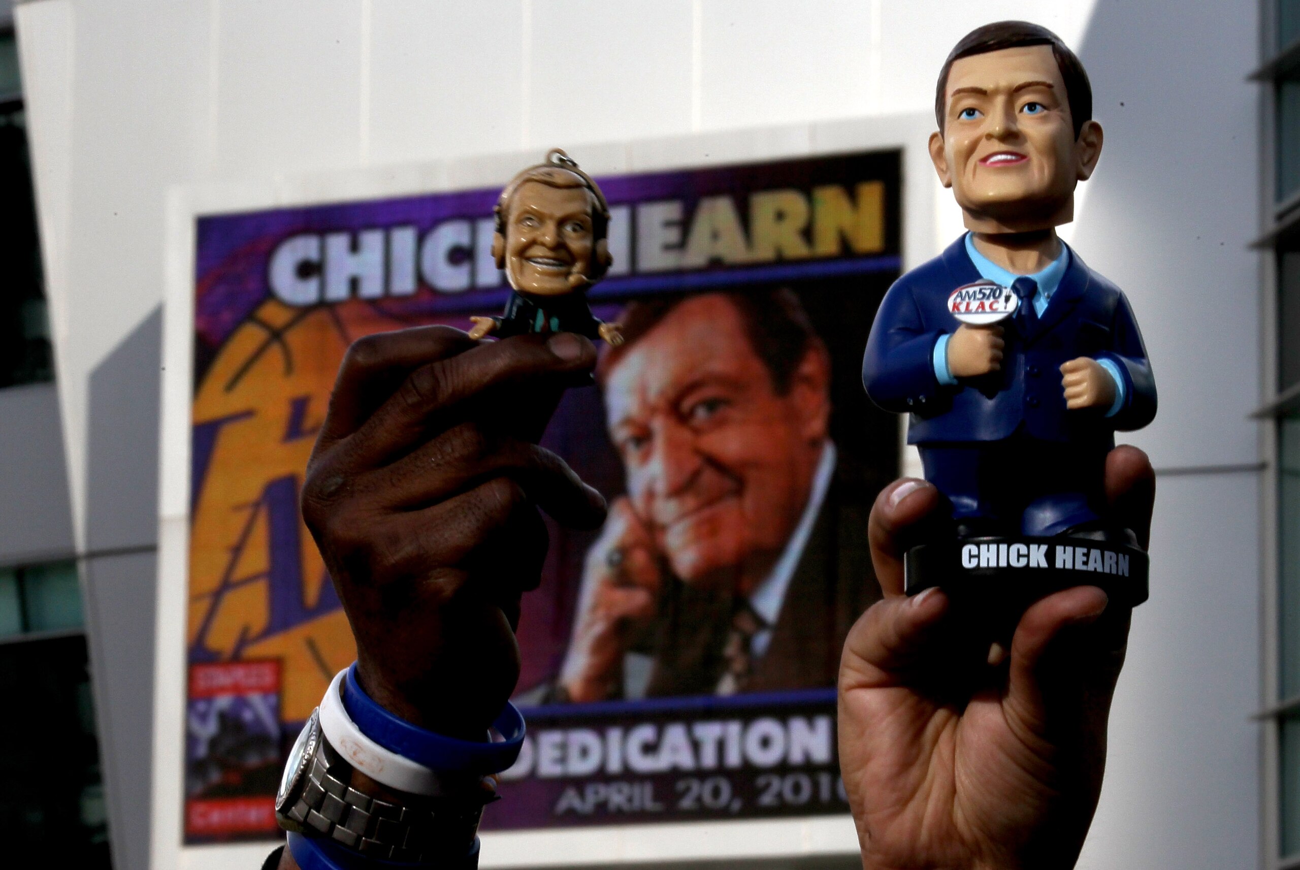 LOS ANGELES, CA - APRIL 20:  Fans hold up old souvenir figures of Los Angeles Lakers broadcaster Chick Hearn during unveiling ceremonies of a staute of Hearn before the Los Angeles Lakers and the Oklahoma City Thunder's  Game Two of the Western Conference