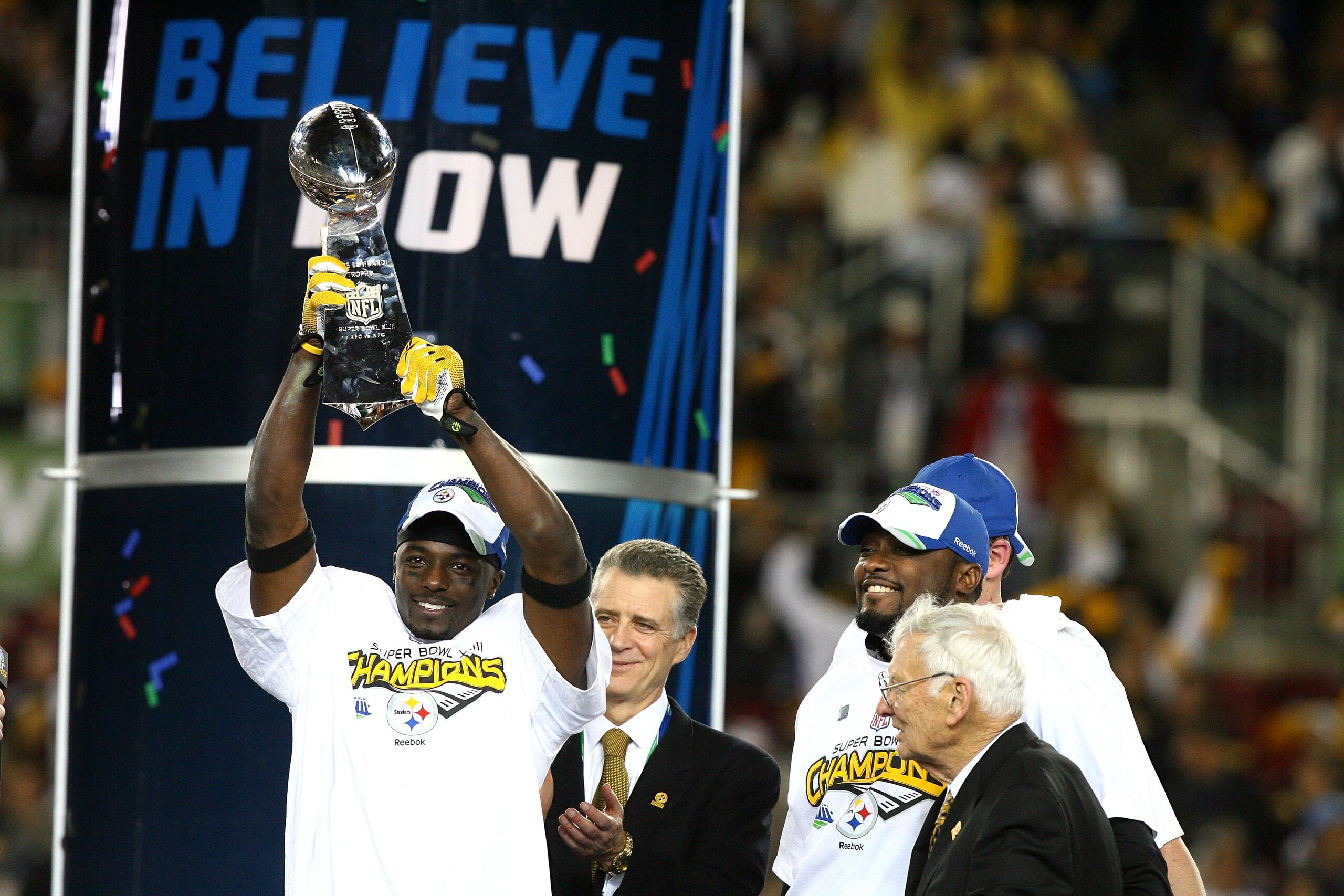TAMPA, FL - FEBRUARY 01:  Santonio Holmes #10 of of the Pittsburgh Steelers celebrates with the Vince Lombardi Trophy as team owner Dan Rooney and head coach Mike Tomlin looks on after the Steelers won 27-23 against the Arizona Cardinals during Super Bowl