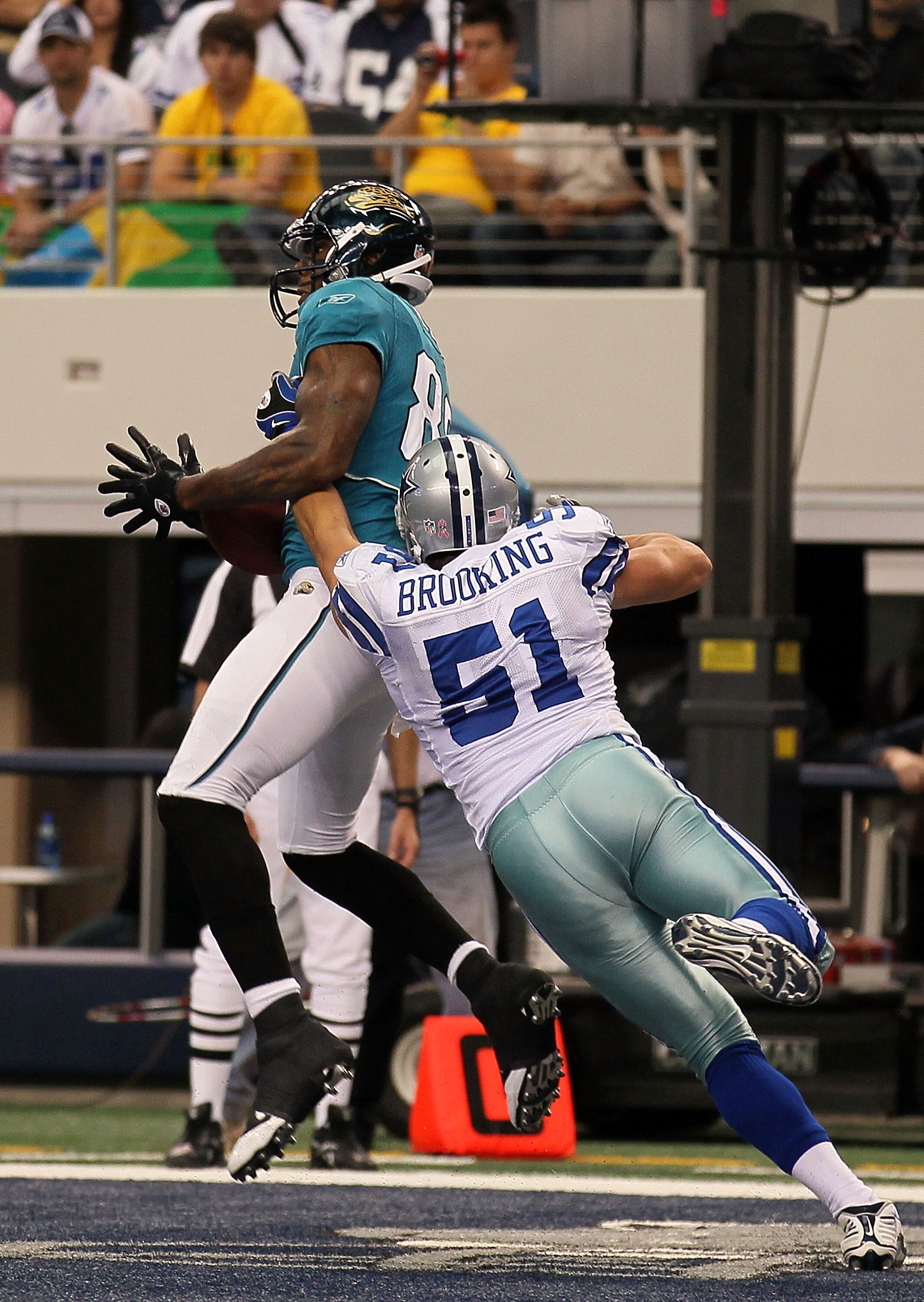 ARLINGTON, TX - OCTOBER 31:  Marcedes Lewis #89 of the Jacksonville Jaguars catches a 9-yard touchdown reception in the third quarter against Keith Brooking #51 of the Dallas Cowboys at Cowboys Stadium on October 31, 2010 in Arlington, Texas.  (Photo by S
