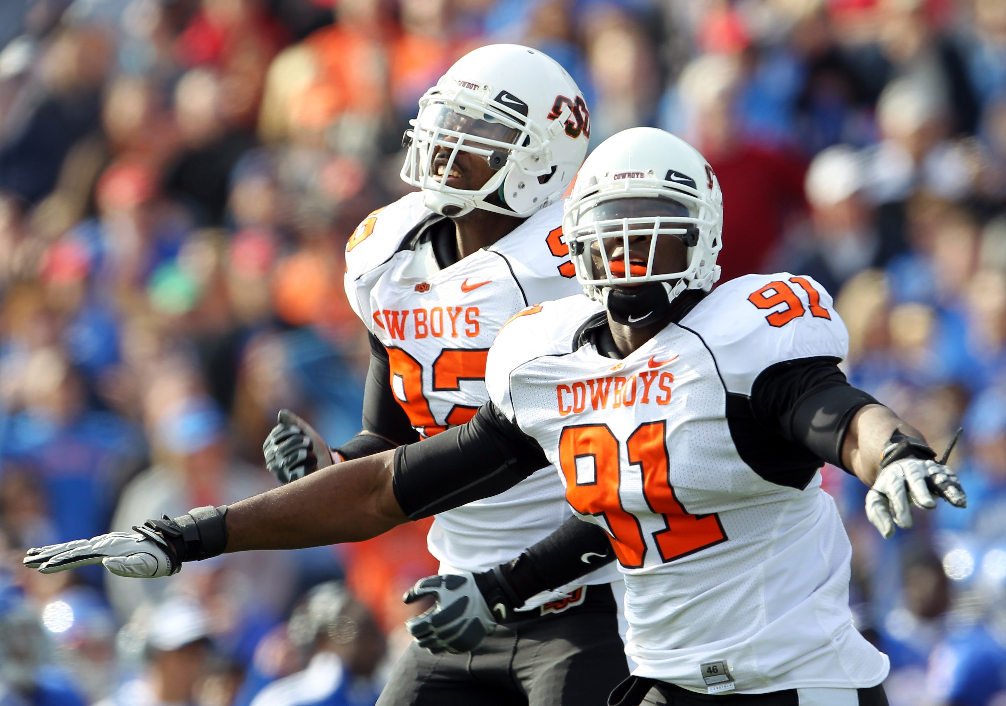 LAWRENCE, KS - NOVEMBER 20: Ugo Chinasa #91 and Darius Hart #92 of the Oklahoma State Cowboys celebrate after the Cowboys stopped the Kansas Jayhawks from scoring at the goal line during the game on November 20, 2010 at Memorial Stadium in Lawrence, Kans LAWRENCE, KS - NOVEMBER 20: Ugo Chinasa #91 and Darius Hart #92 of the Oklahoma State Cowboys celebrate after the Cowboys stopped the Kansas Jayhawks from scoring at the goal line during the game on November 20, 2010 at Memorial Stadium in Lawrence, Kans
