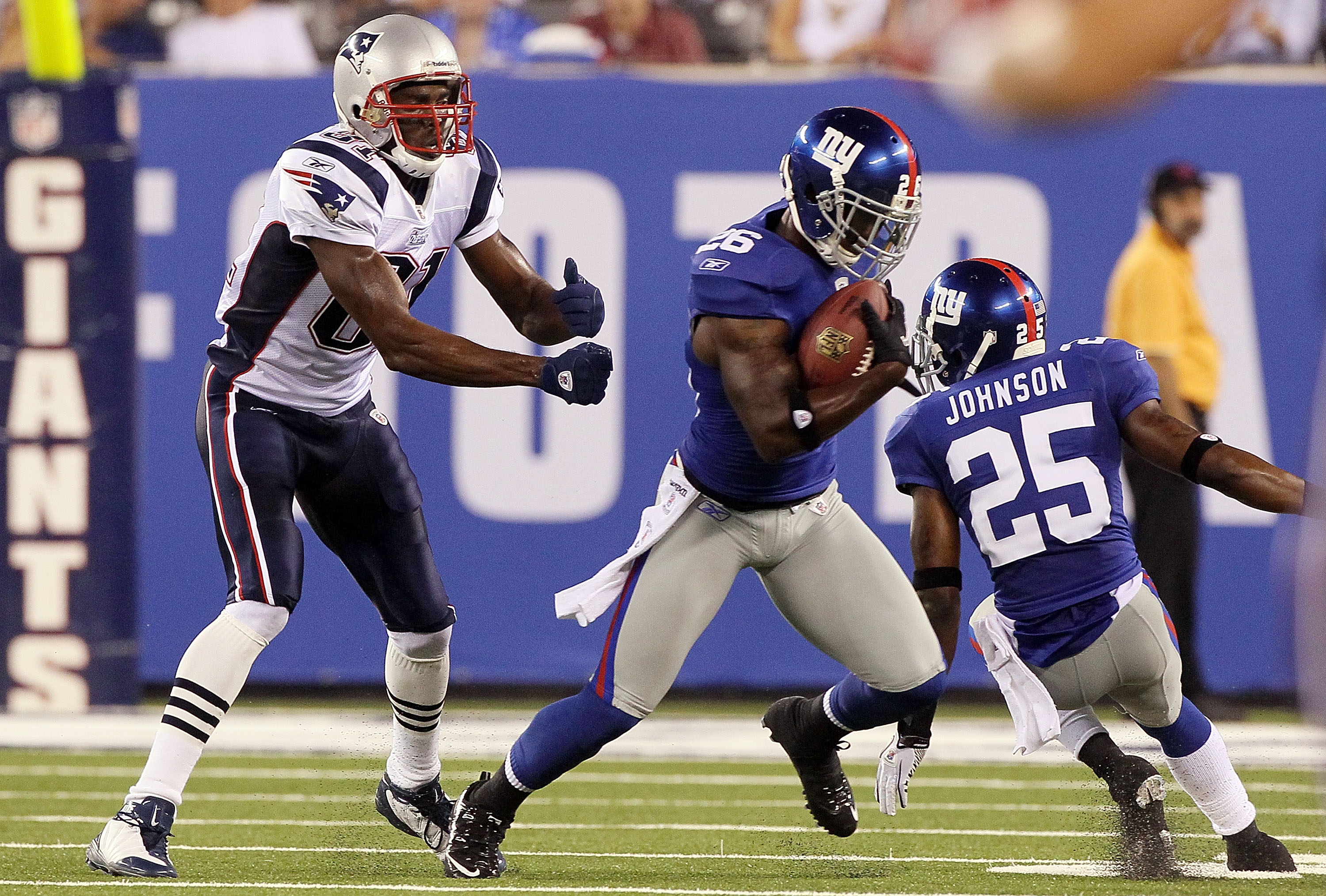 EAST RUTHERFORD, NJ - SEPTEMBER 02:  Antrel Rolle #26 of the New York Giants intercepts a pass intended for Randy Moss #81 of the New England Patriots during the first quarter on September 2, 2010 at the New Meadowlands Stadium in East Rutherford, New Jer