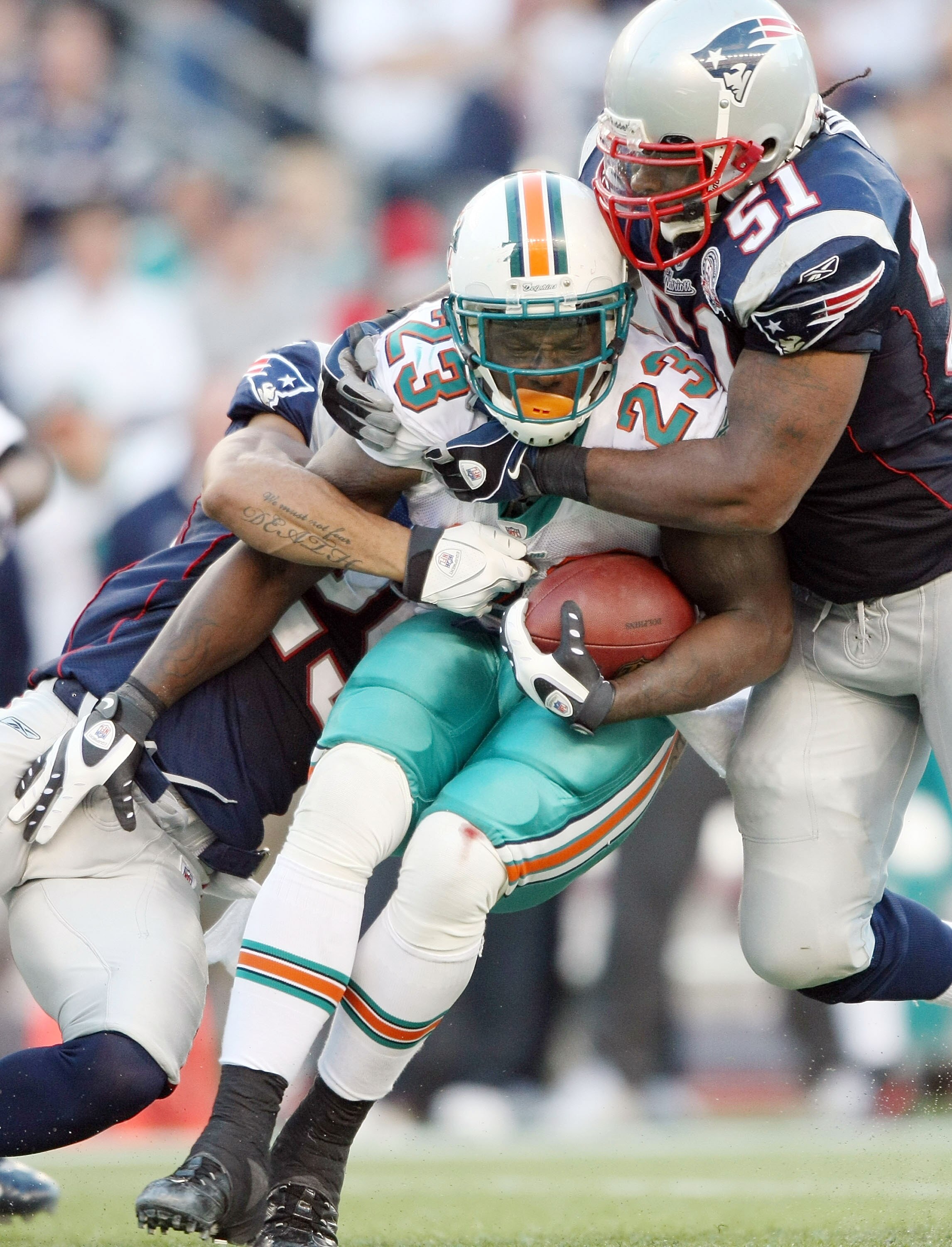 FOXBORO, MA - NOVEMBER 08:  Ronnie Brown #23 of the Miami Dolphins is stopped by Pat Chung #25 and Jerod Mayo #51 of the New England Patriots on November 8, 2009 at Gillette Stadium in Foxboro, Massachusetts. The Patriots defeated the Dolphins 27-17.  (Ph