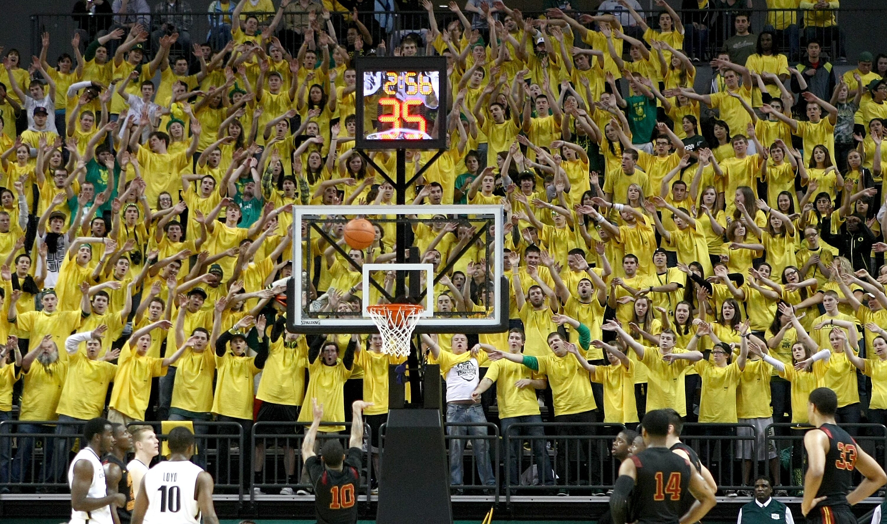 EUGENE, OR - JANUARY 13:  Members of the 'Pit Crew' wave their hands as Maurice Jones #10 of the USC Trojans shoots a free against the Oregon Ducks during the grand opening of the Matthew Knight Arena on January 13, 2011 at Matthew Knight Arena in Eugene,