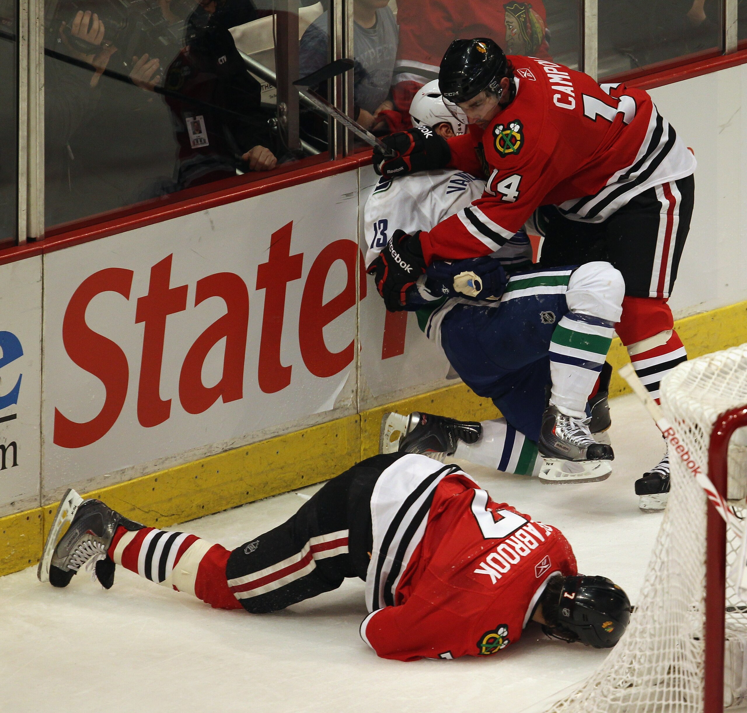 CHICAGO, IL - APRIL 17: Chris Campoli #14 of the Chicago Blackhawks hits Raffi Torres #13 of the Vancouver Canucks after Torres knocked down Brent Seabrook #7 with a hit behind the net in Game Three of the Western Conference Quarterfinals during the 2011