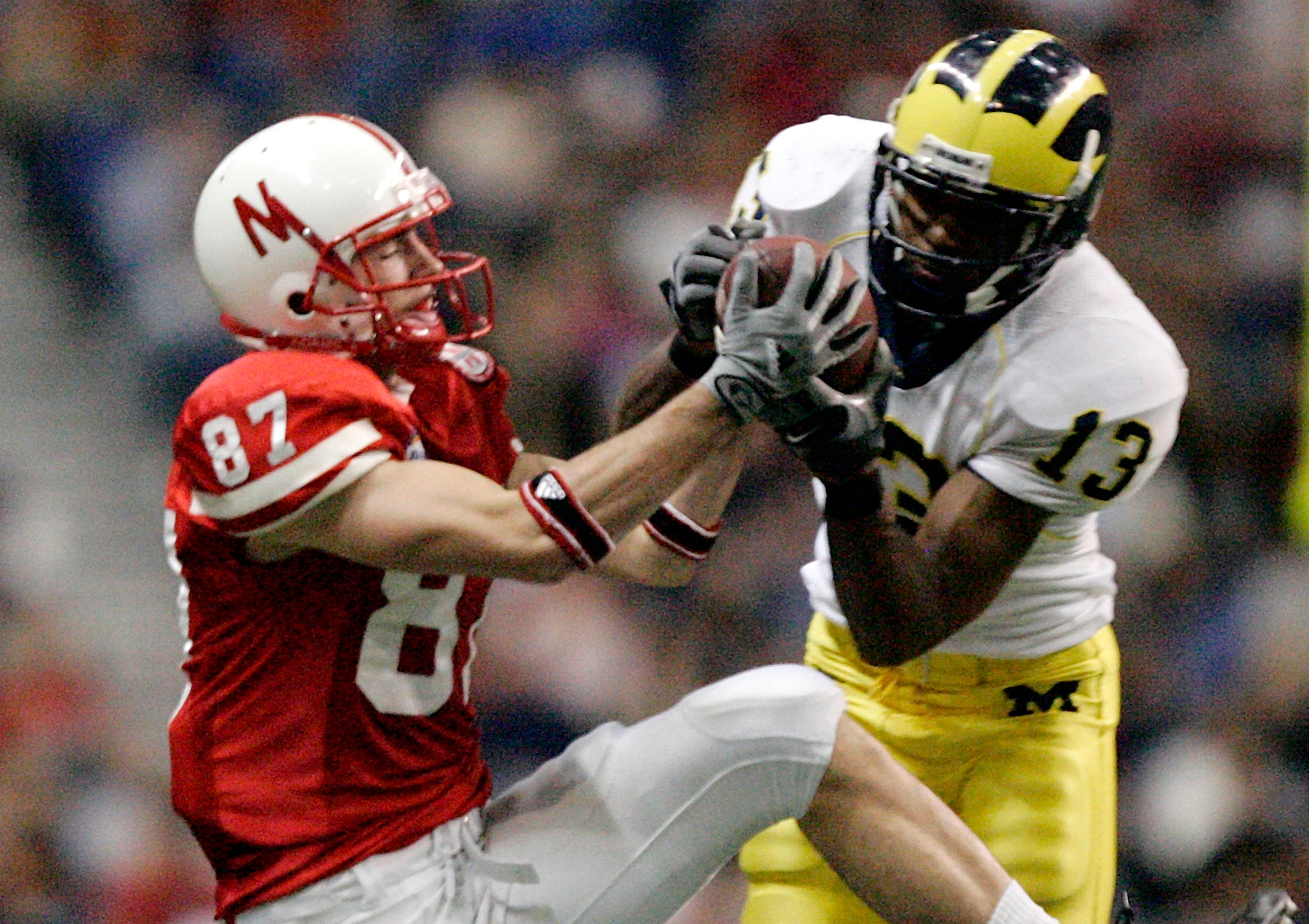 SAN ANTONIO - DECEMBER 28:  Cornerback Grant Mason #13 of the Michigan Wolverines nearly intercepts a pass intended for wide receiver Nate Swift #87 of the Nebraska Cornhuskers during the third quarter of the MasterCard Alamo Bowl on December 28, 2005 at