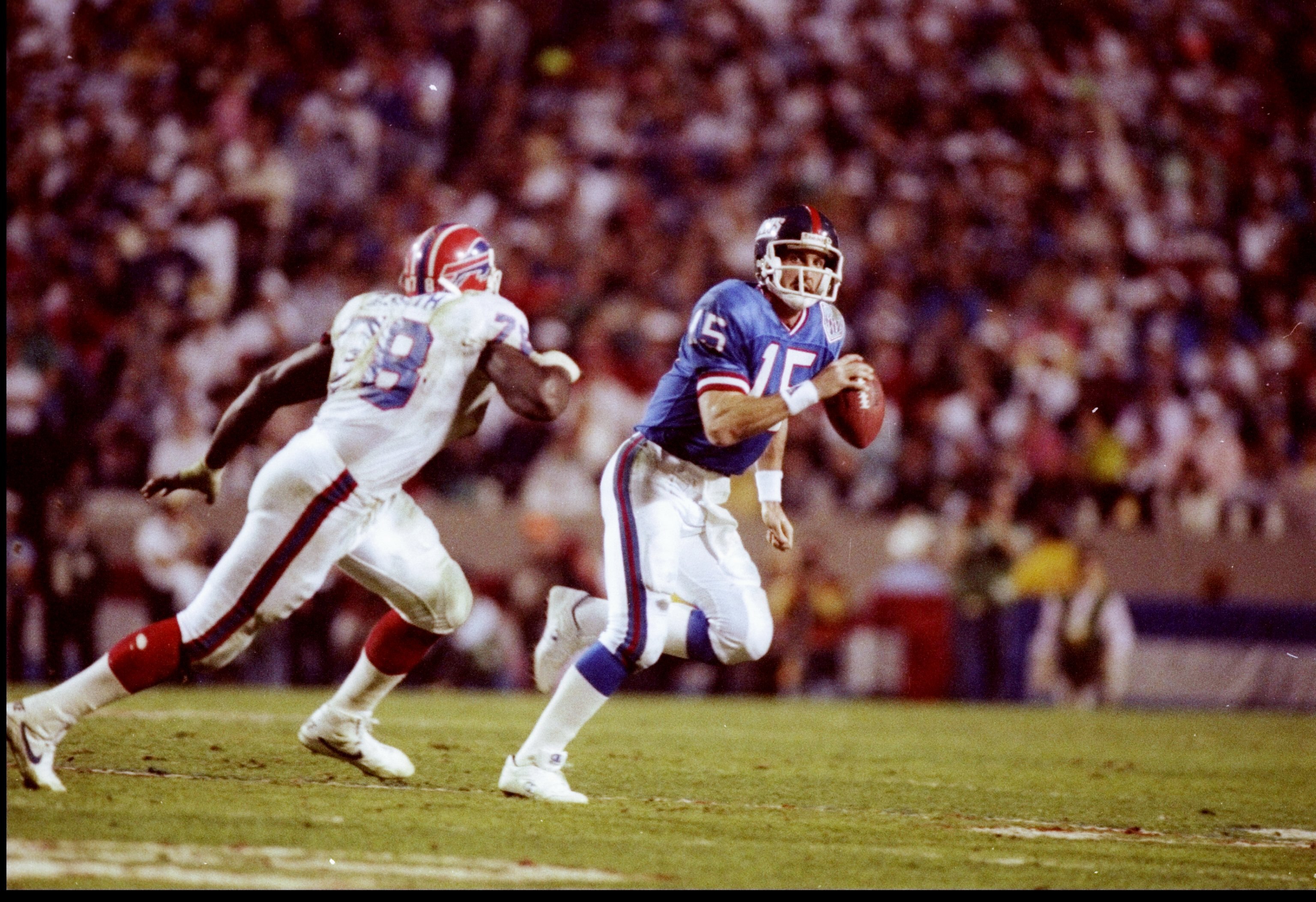 27 Jan 1991: Quarterback Jeff Hostetler of the New York Giants (right) moves the ball as Buffalo Bills defensive lineman Bruce Smith chases him during Super Bowl XXV at Tampa Stadium in Tampa, Florida. The Giants won the game, 20-19.