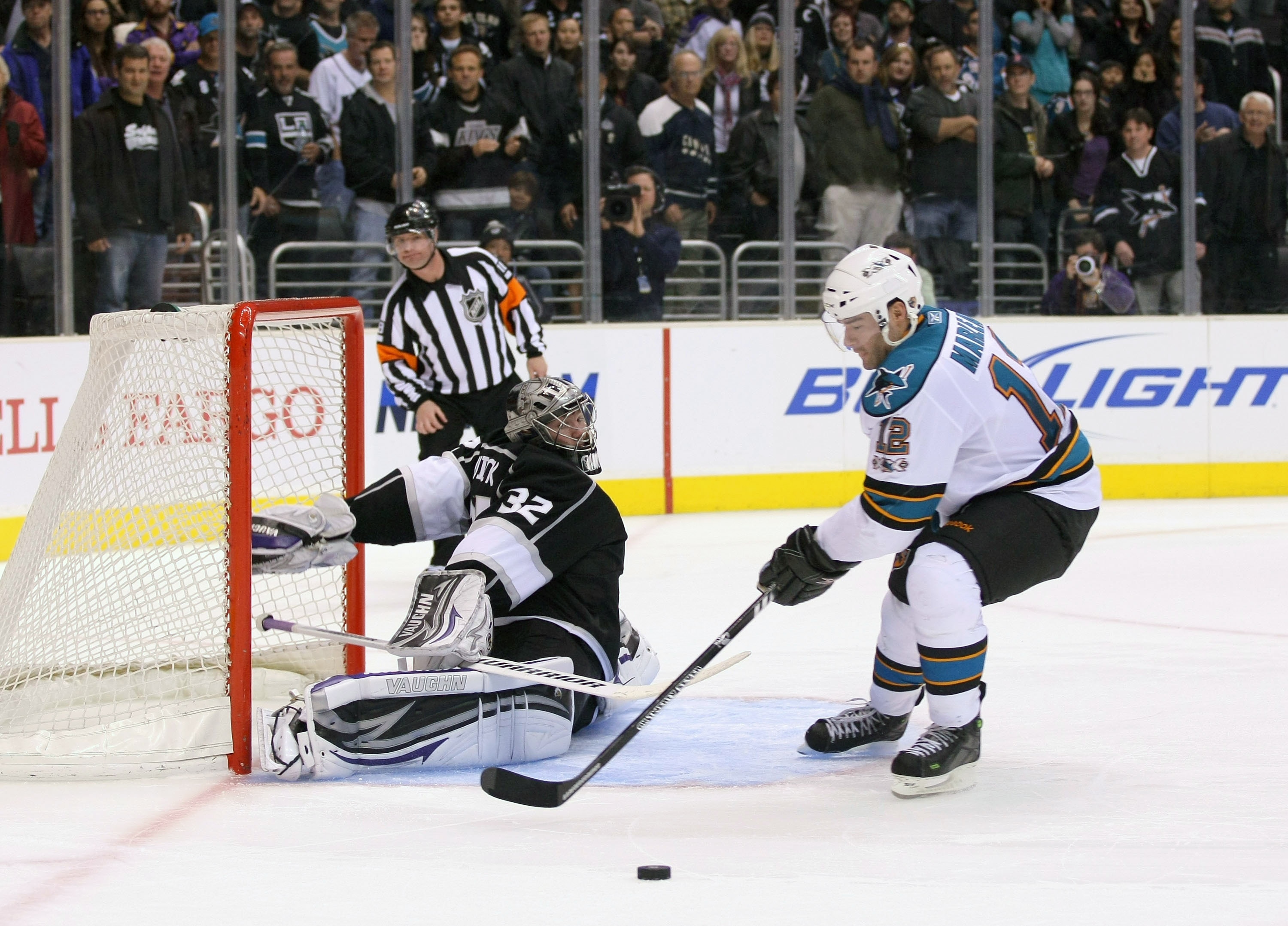 LOS ANGELES, CA - MARCH 24:  Goaltender Jonathan Quick #32 of the Los Angeles Kings slides out his right leg pad to defend the shot as Patrick Marleau #12 of the San Jose Sharks loses control of the puck during his shootout attempt in the NHL game at Stap