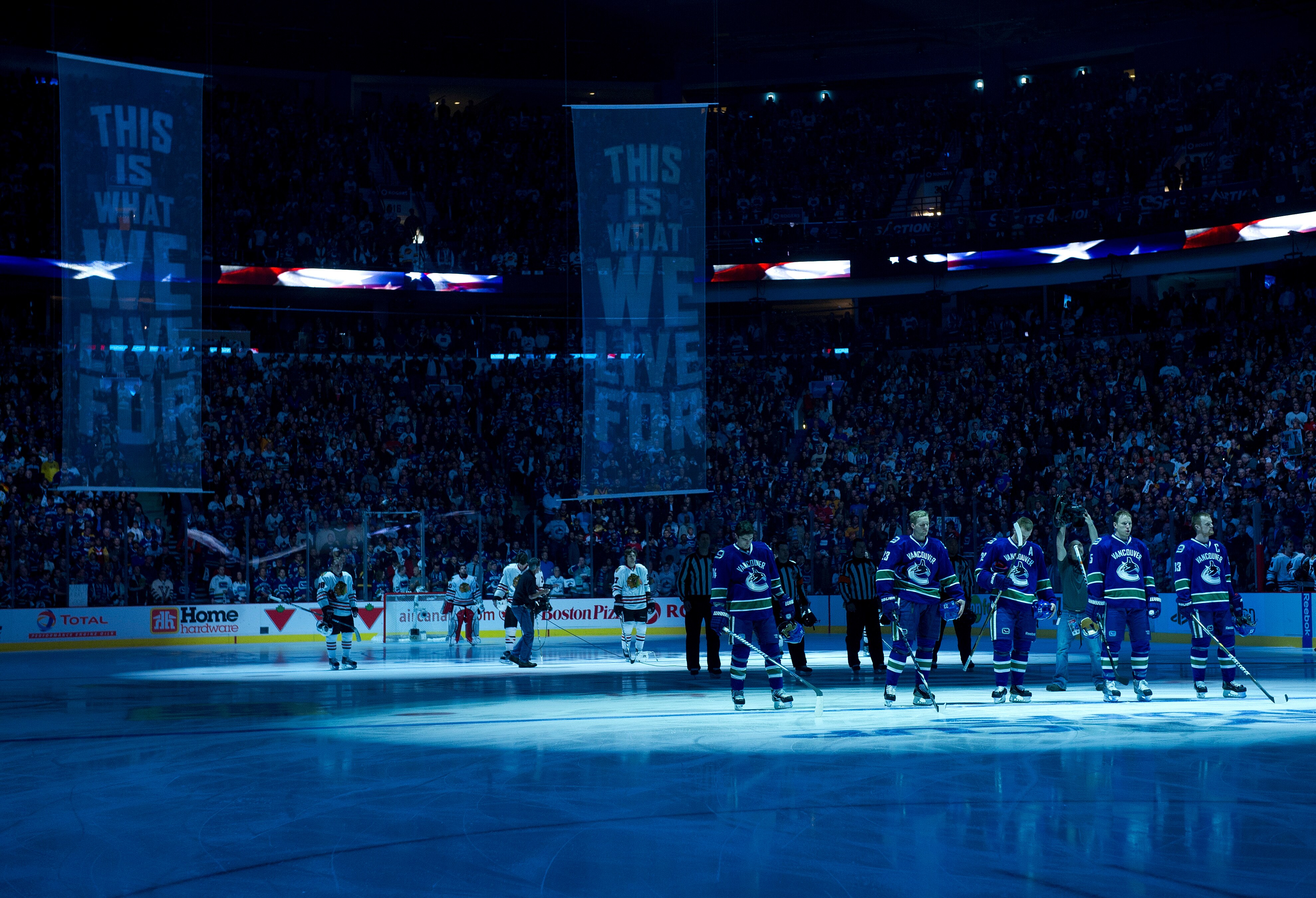 VANCOUVER, CANADA - APRIL 15: The Vancouver Canucks and the Chicago Blackhawks stand on their respective blue lines for the singing of the national anthems prior to the start of Game Two of the Western Conference Quarterfinals during the 2011 NHL Stanley