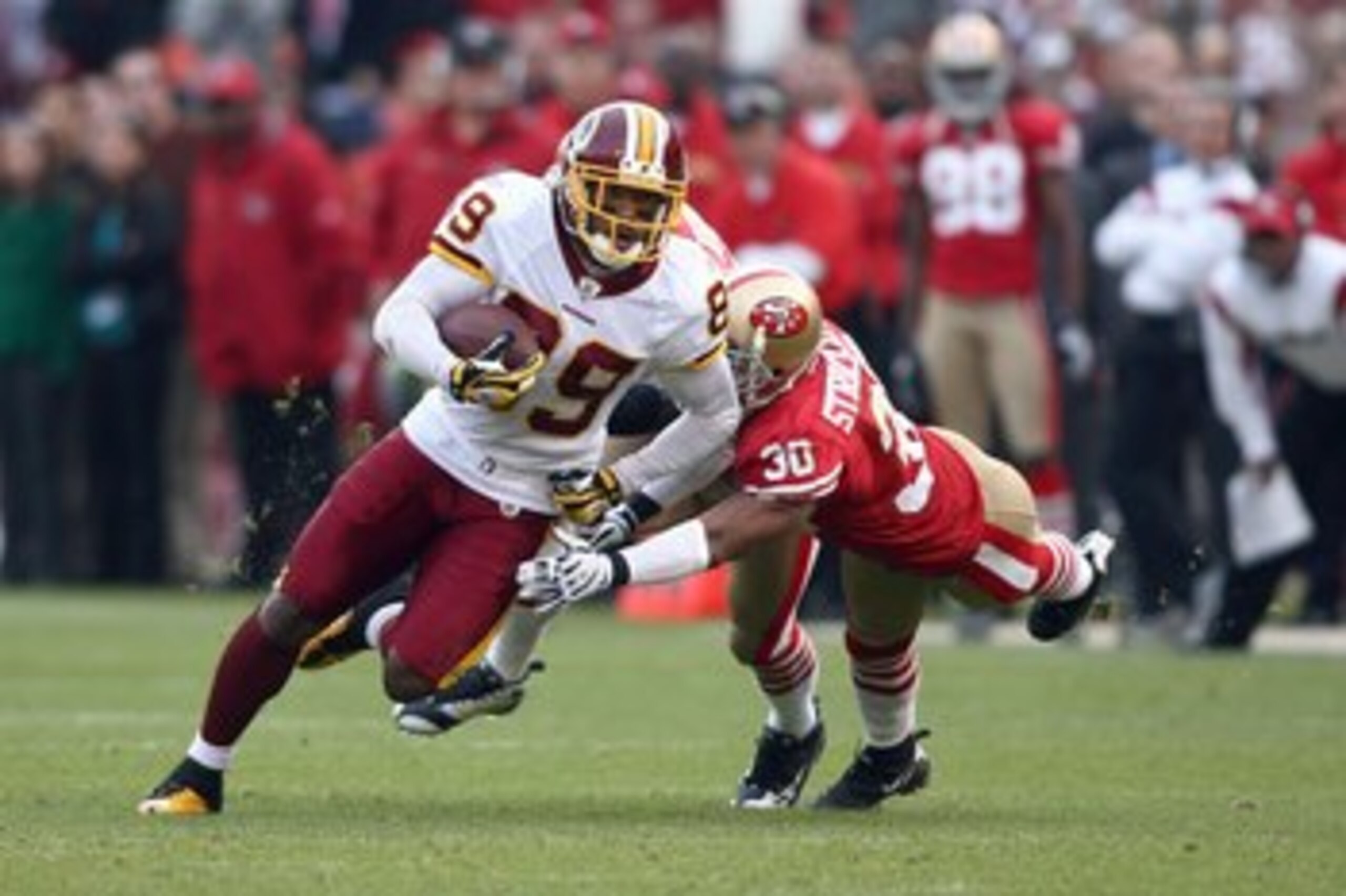 SAN FRANCISCO - DECEMBER 28:  Santana Moss #89 of the Washington Redskins carries the ball as he evades Donald Strickland #30 of the San Fransisco 49ers at Candlestick Park on December 28, 2008 in San Francisco, California. (Photo by: Jonathan Ferrey/Gett