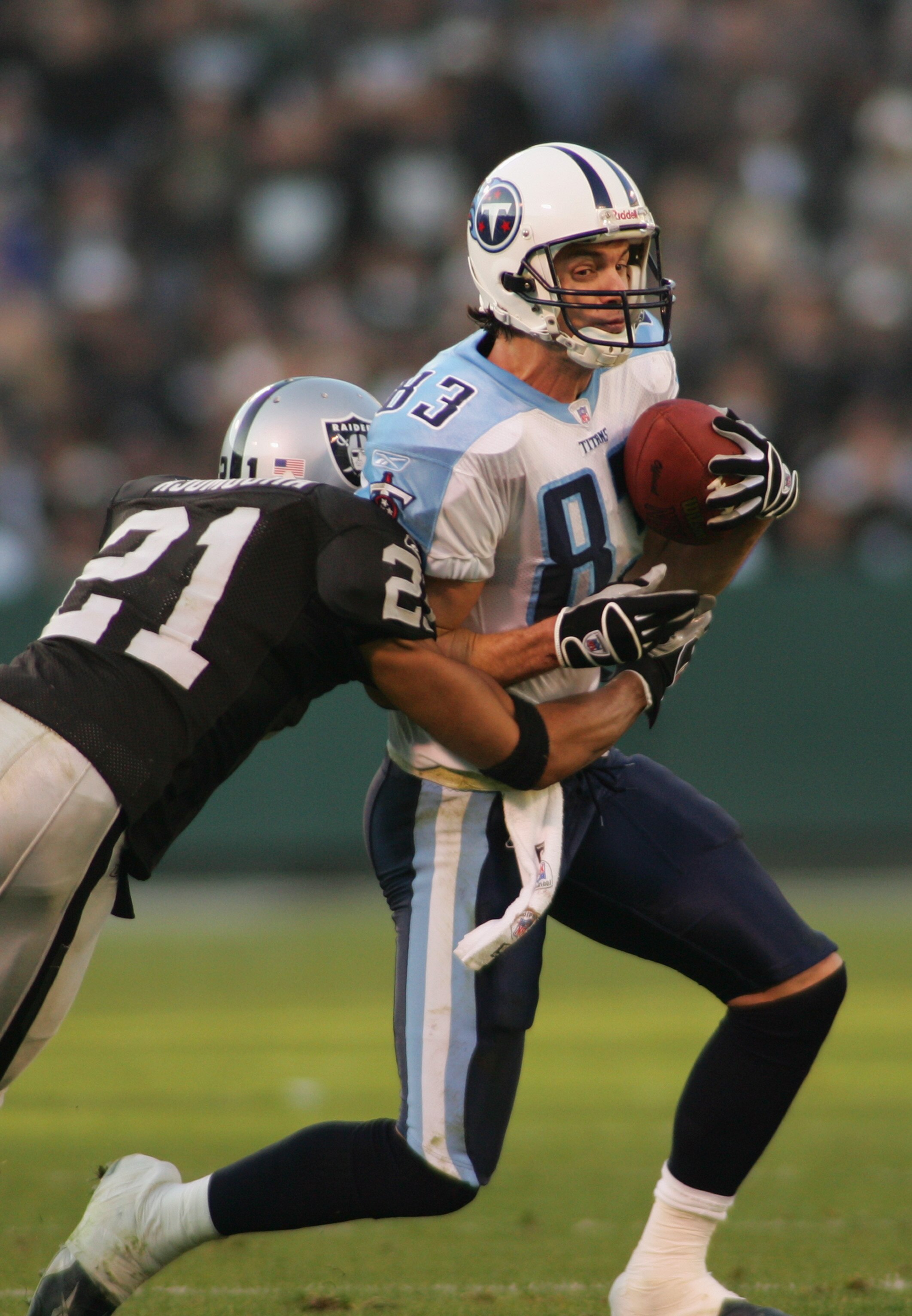 OAKLAND, CA - DECEMBER 19:  Wide receiver Drew Bennett #83 of the Tennessee Titans runs against cornerback Nnamdi Asomugha #21 of the Oakland Raiders on December 19, 2004 at Network Associates Coliseum in Oakland, California. The Raiders defeated the Tita