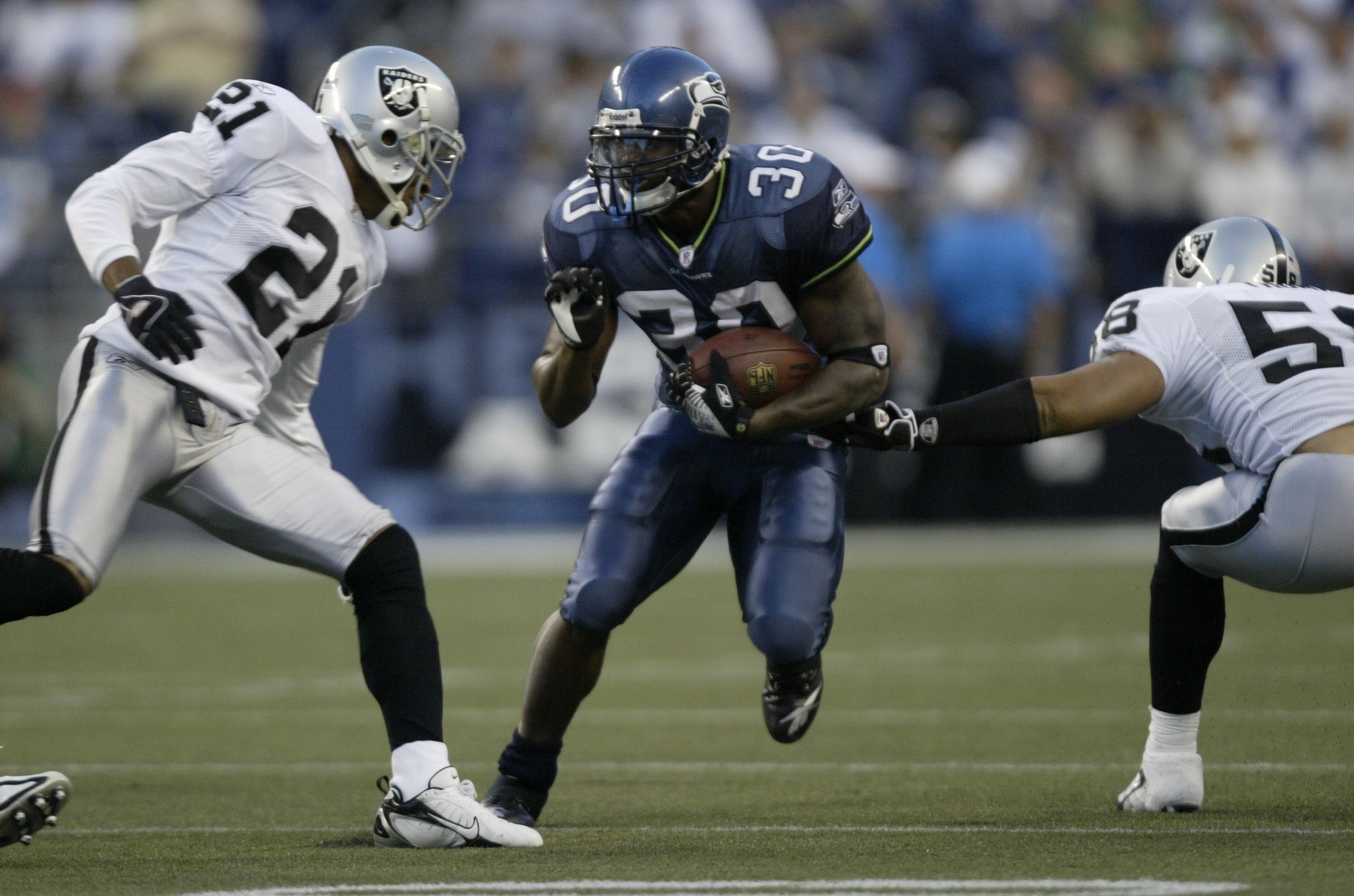 SEATTLE - AUGUST 31:  Runningback Marquis Weeks #30 of the Seattle Seahawks rushes against Nnamdi Asomugha #21 and Robert Thomas #58 of the Oakland Raiders on August 31, 2006 at Qwest Field in Seattle, Washington. (Photo by Otto Greule Jr/Getty Images)