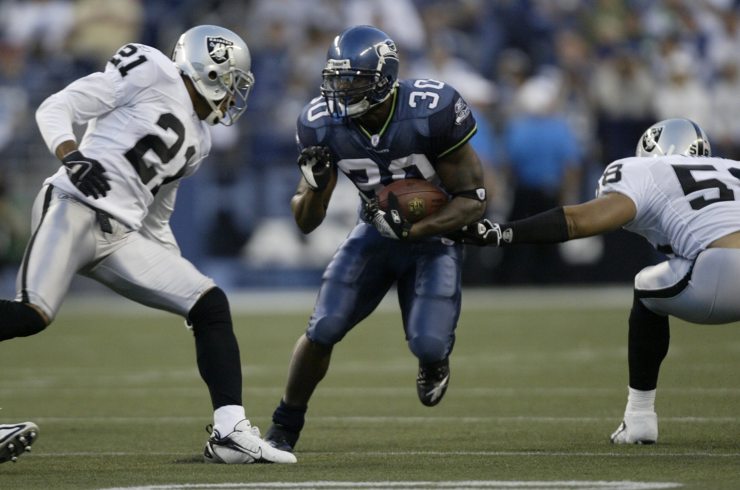 SEATTLE - AUGUST 31:  Runningback Marquis Weeks #30 of the Seattle Seahawks rushes against Nnamdi Asomugha #21 and Robert Thomas #58 of the Oakland Raiders on August 31, 2006 at Qwest Field in Seattle, Washington. (Photo by Otto Greule Jr/Getty Images)