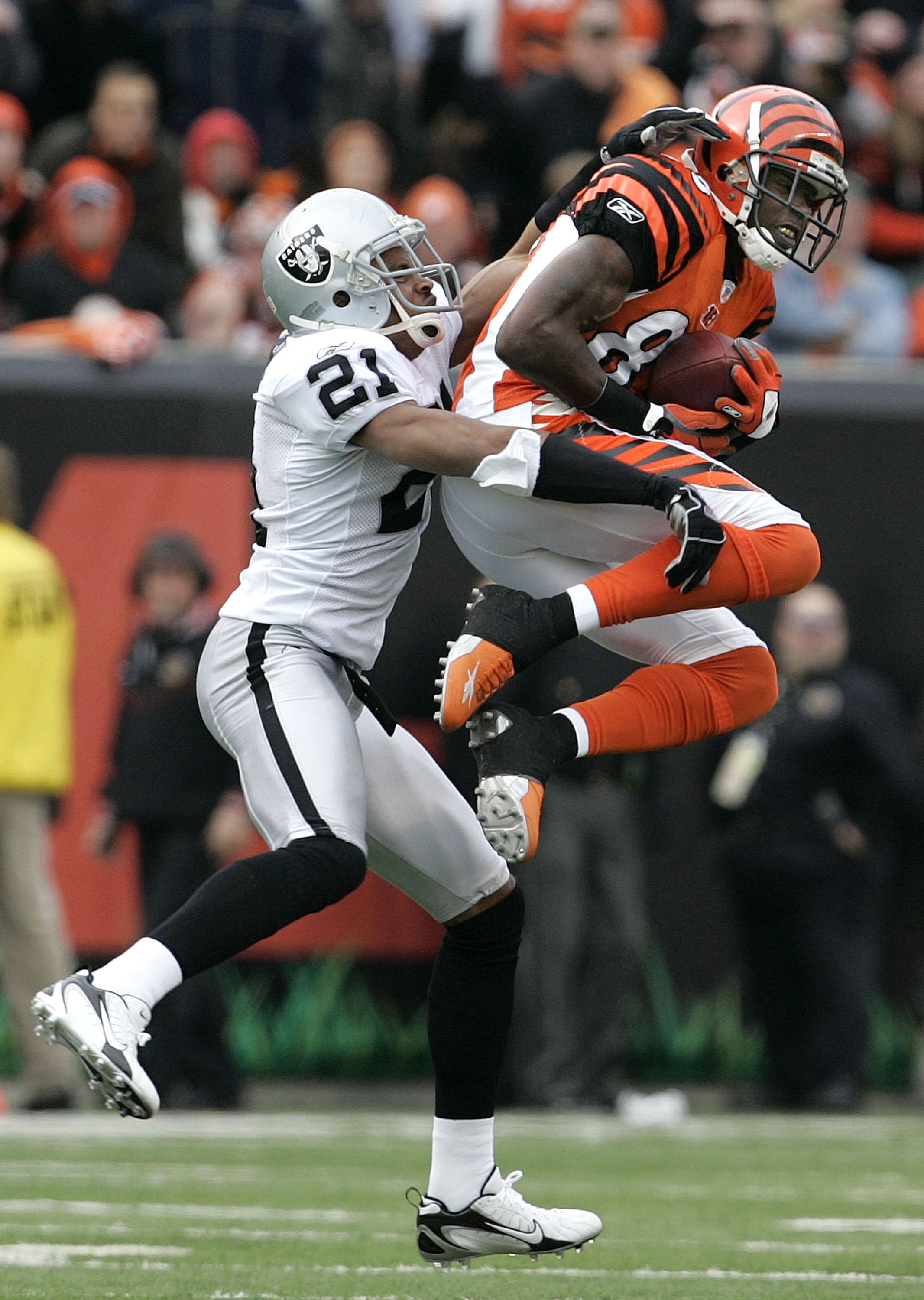 CINCINNATI - DECEMBER 10:  Chad Johnson #85 of the Cincinnati Bengals catches a pass against Nnamdi Asomugha #21 of the Oakland Raiders during the second quarter on December 10, 2006 at Paul Brown Stadium in Cincinnati, Ohio.  (Photo by David Maxwell/Gett