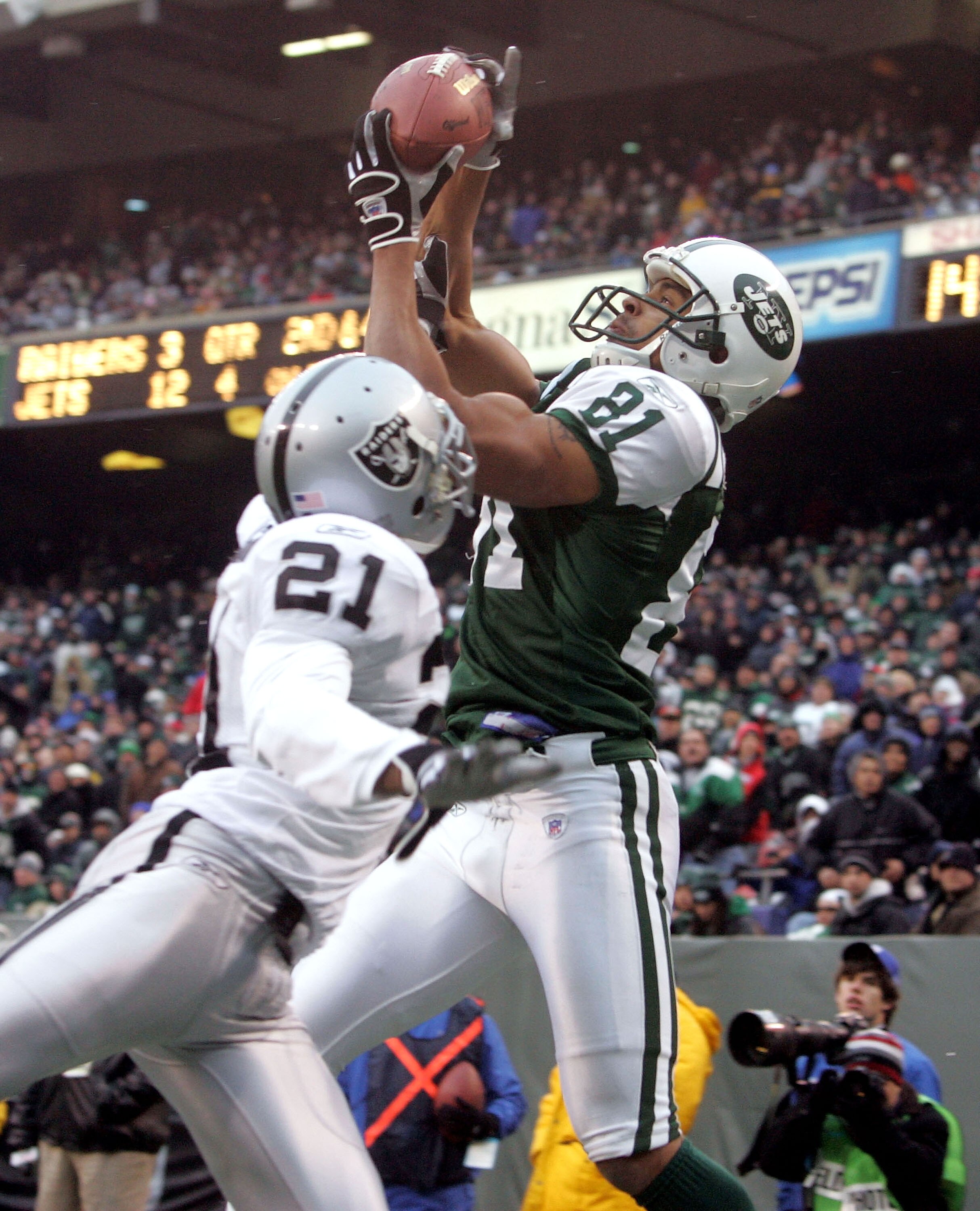 EAST RUTHERFORD, NJ - DECEMBER 11:  Wide receiver Justin McCareins #81 of the New York Jets catches a touchdown pass in the fourth quarter against cornerback Nnamdi Asomugha #21 of the Oakland Raiders on December 11, 2005 at Giants Stadium in East Rutherf