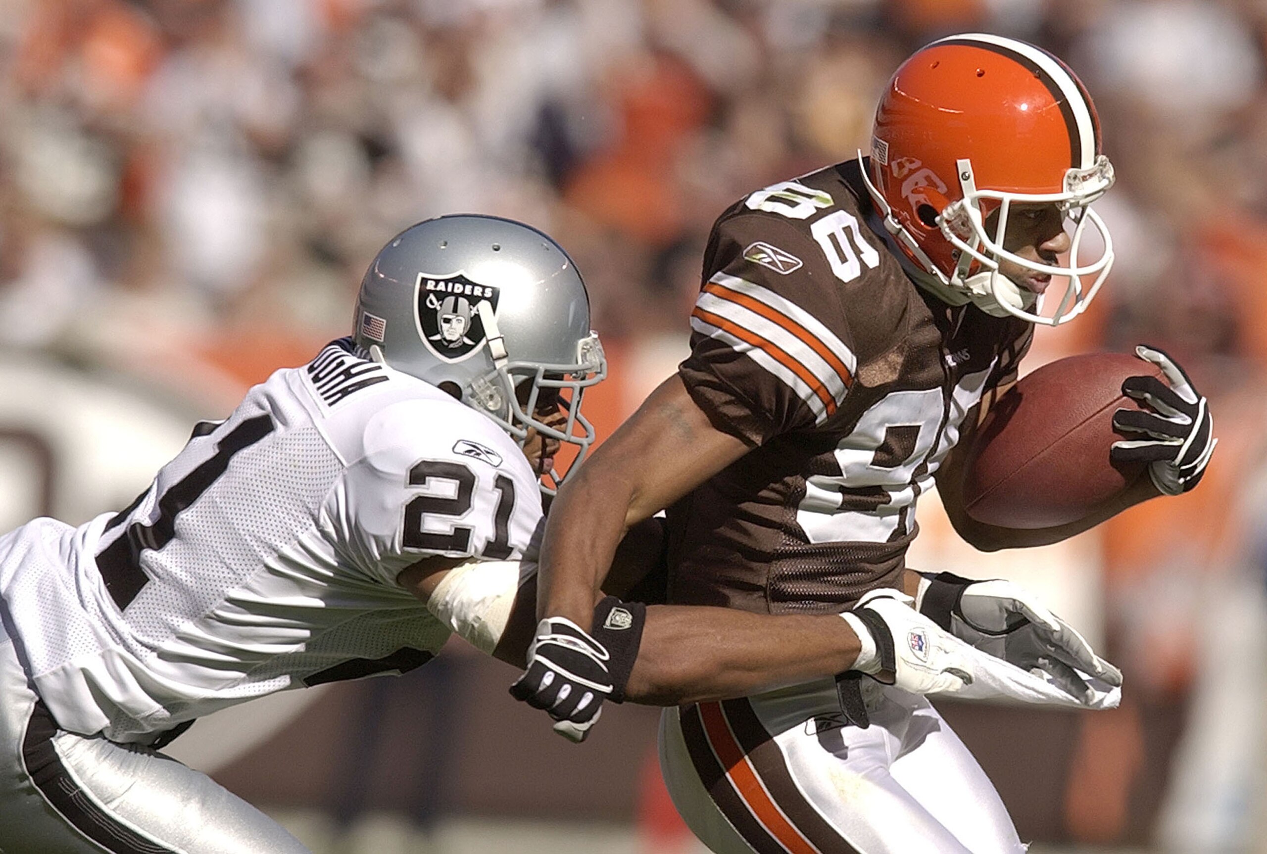 CLEVELAND, OH - OCTOBER 12:  Wide receiver Dennis Northcutt #86 of the Cleveland Browns is tackled by Nnamdi Asomugha of the Oakland Raiders during the third quarter on October 12, 2003 at Cleveland Browns Stadium in Cleveland, Ohio. The Browns defeated t