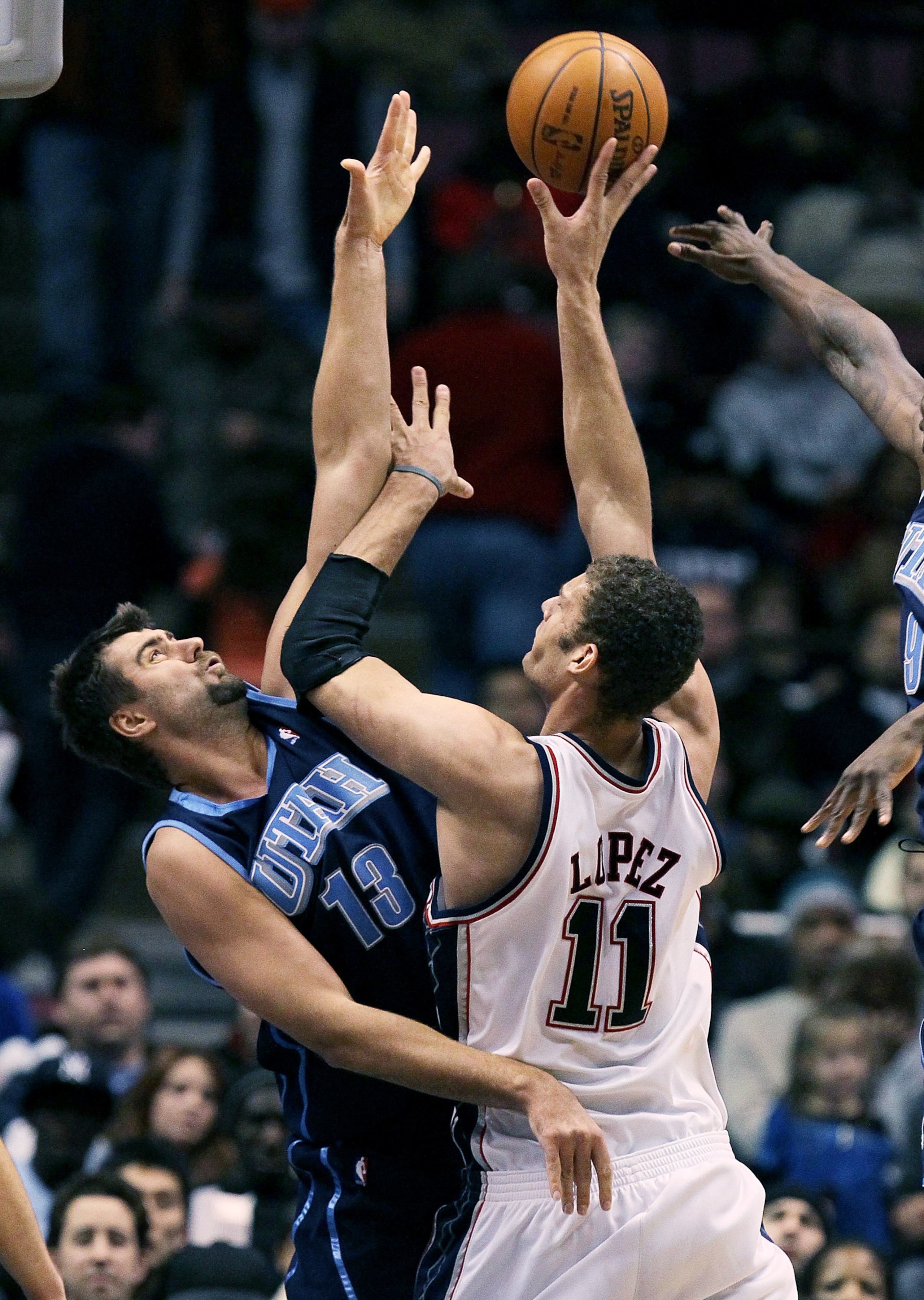 EAST RUTHERFORD, NJ - DECEMBER 16: Brook Lopez #11 of the New Jersey Nets shoots over Mehmet Okur #13 of the Utah Jazz during their game on December 16, 2009 at the IZOD Center in East Rutherford, New Jersey. NOTE TO USER: User expressly acknowledges an EAST RUTHERFORD, NJ - DECEMBER 16: Brook Lopez #11 of the New Jersey Nets shoots over Mehmet Okur #13 of the Utah Jazz during their game on December 16, 2009 at the IZOD Center in East Rutherford, New Jersey. NOTE TO USER: User expressly acknowledges an