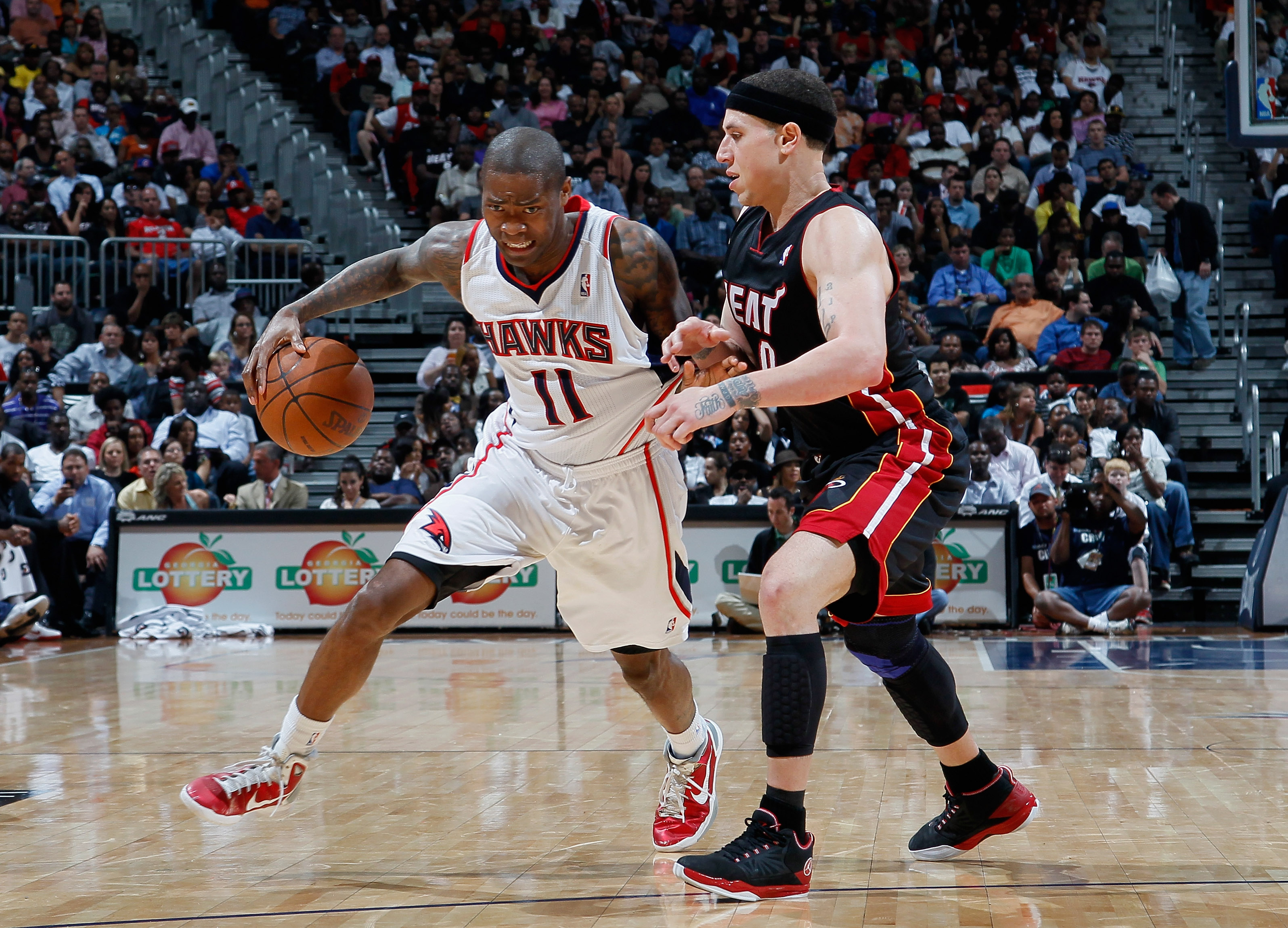 ATLANTA, GA - APRIL 11:  Jamal Crawford #11 of the Atlanta Hawks drives against Mike Bibby #0 of the Miami Heat at Philips Arena on April 11, 2011 in Atlanta, Georgia.  NOTE TO USER: User expressly acknowledges and agrees that, by downloading and/or using