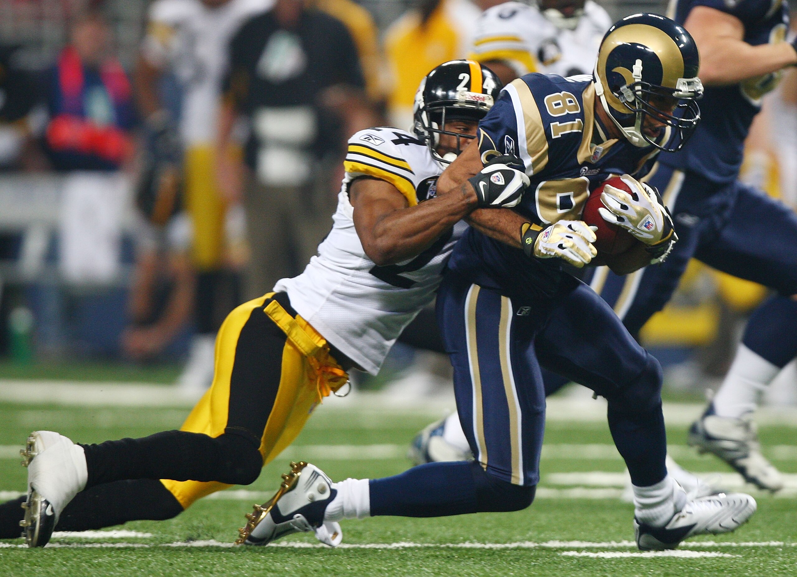 ST. LOUIS - DECEMBER 20:  Torry Holt #81 of the St. Louis Rams is pulled down by Ike Taylor #24 of the Pittsburgh Steelers on December 20, 2007 at Edward Jones Dome in St. Louis, Missouri.  (Photo by Elsa/Getty Images)