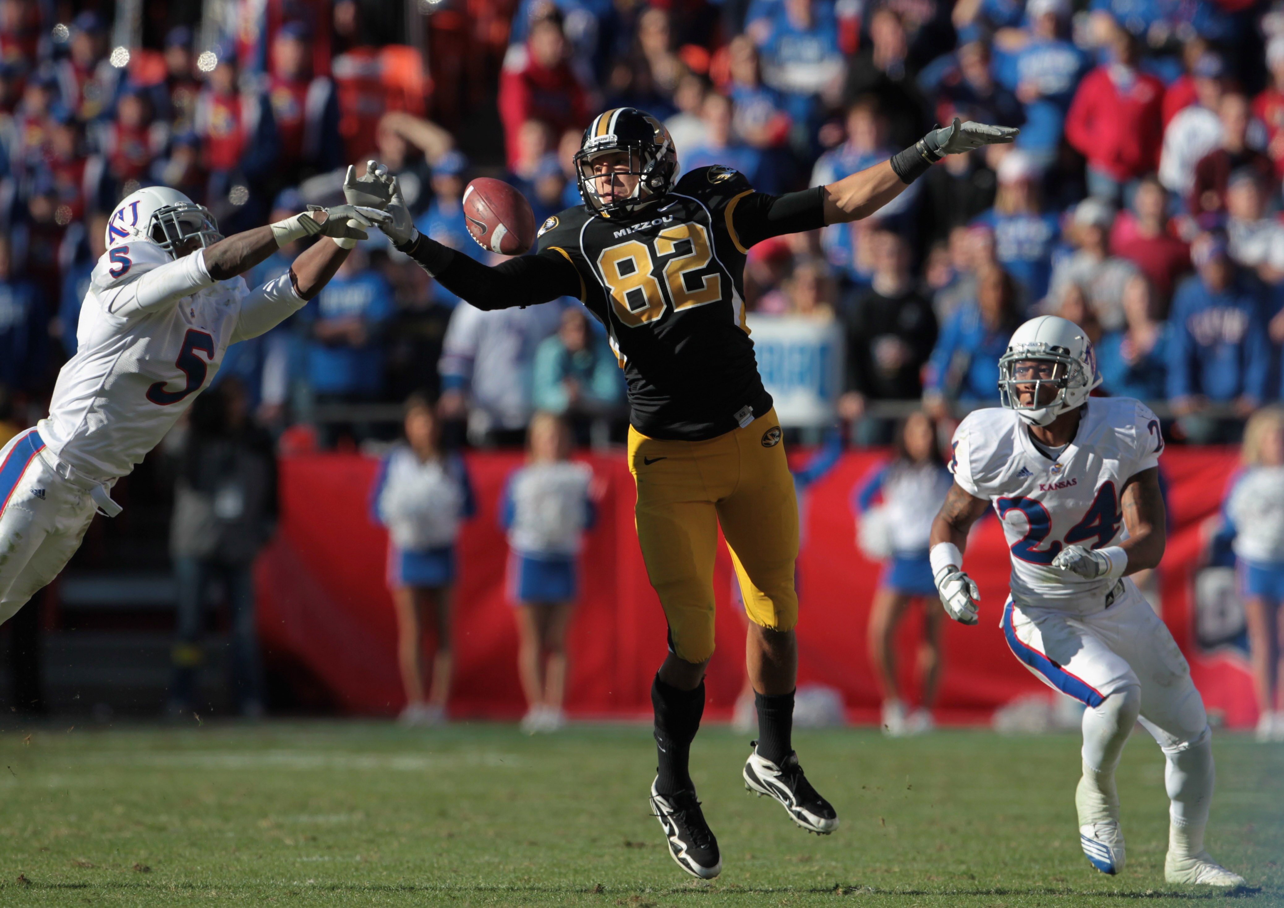 KANSAS CITY, MO - NOVEMBER 27:  Cornerback Greg Brown #5 of the Kansas Jayhawks breaks up a pass intended for Michael Egnew #82 of the Missouri Tigers as Bradley McDougald #24 looks on during the game on November 27, 2010 at Arrowhead Stadium in Kansas Ci