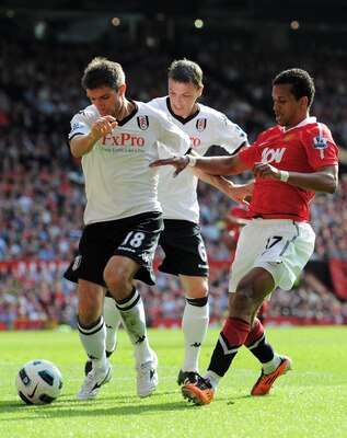 MANCHESTER, ENGLAND - APRIL 09:  Nani of Manchester United is shut out by Aaron Hughes (L) and Chris Baird of Fulham during the Barclays Premier League match between Manchester United and Fulham at Old Trafford on April 9, 2011 in Manchester, England.  (P