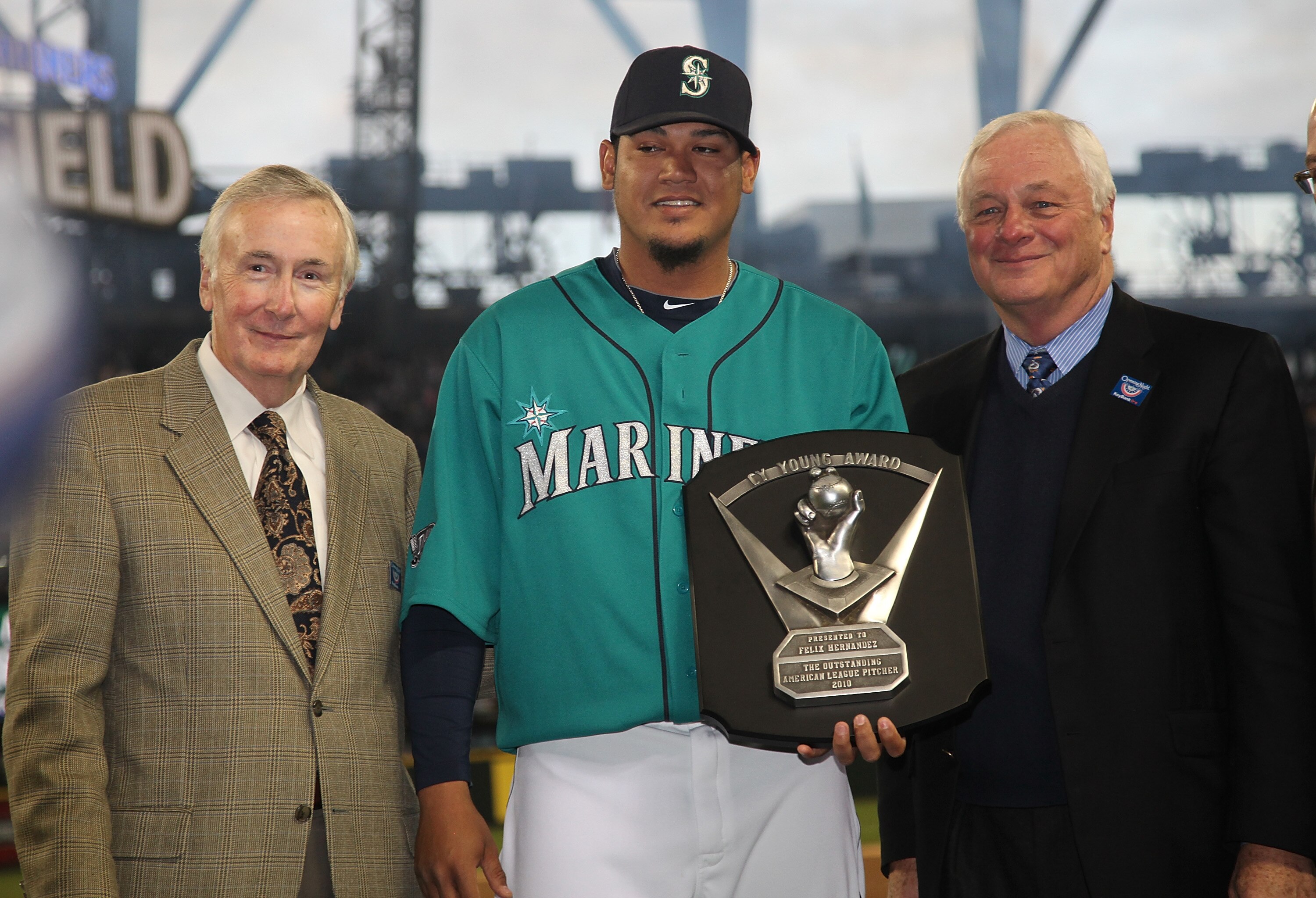 SEATTLE - APRIL 08:  Starting pitcher Felix Hernandez #34 of the Seattle Mariners is flanked by CEO Howard Lincoln (L) and COO Chuck Armstrong after receiving his American League Cy Young Award trophy prior to the Mariners' home opener against the Clevela